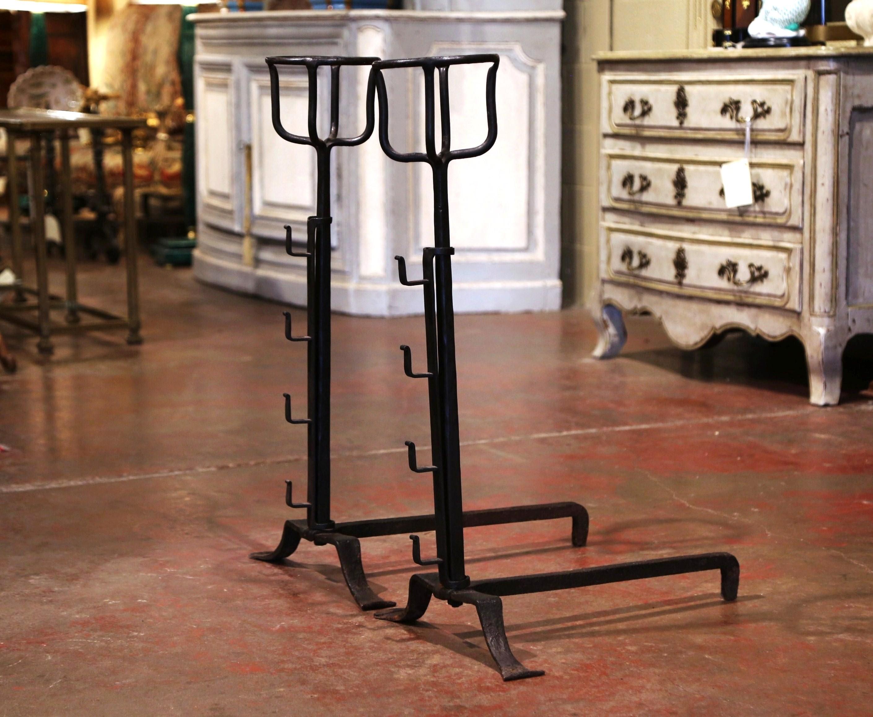 Forged in France, circa 1860, the antique andirons stand on three legs with hooks to hold decorative bar across. They feature a cupped, round shaped top; called a 