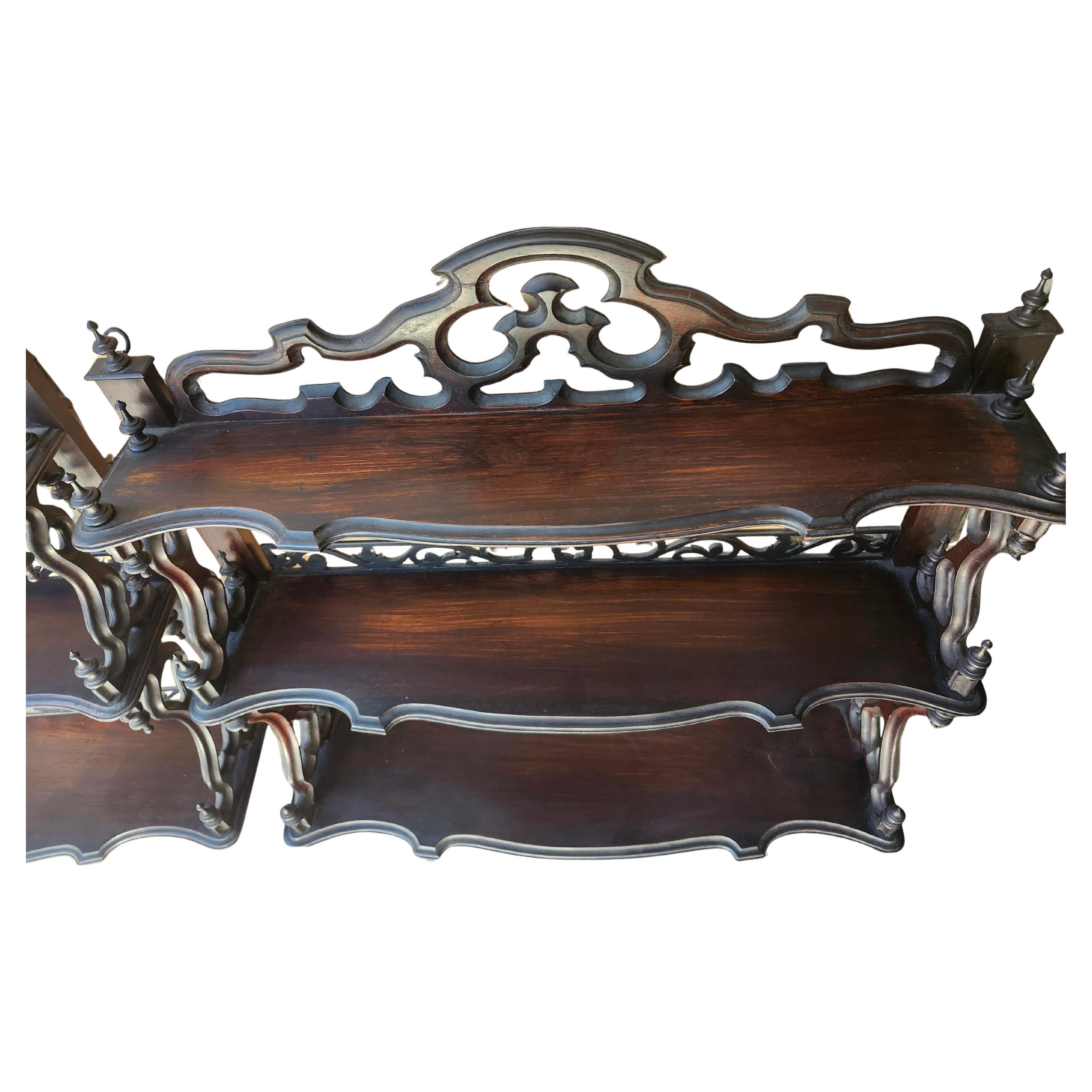 Special pair of fantastic hand carved 3 tier rosewood shelf units. Fabulous carved on all sides and angles, tastefully done in beautiful rosewood. Turned finials abound (1  missing on bottom shelf) which we will try to source out. Pair