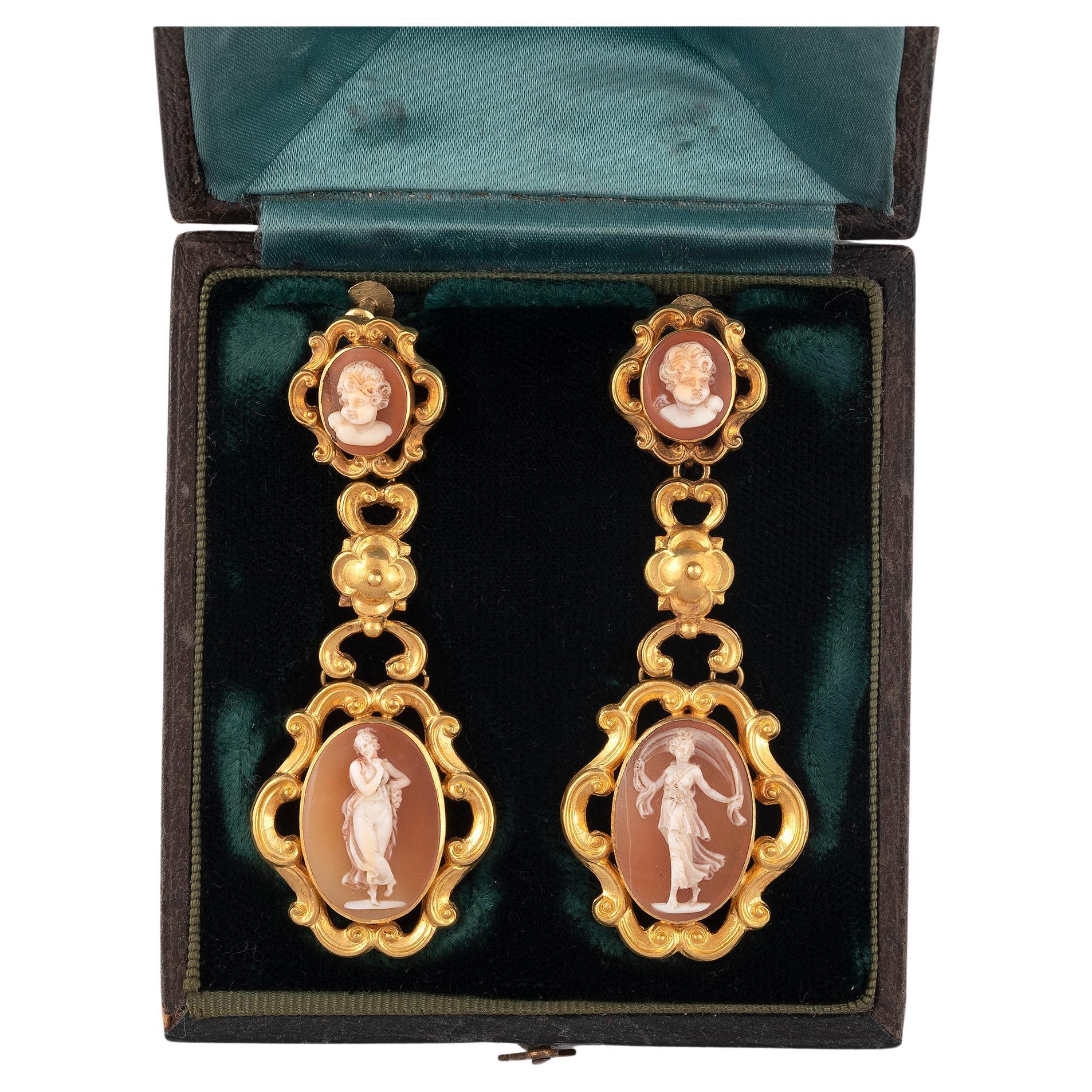 

Die länglich-ovale Kamee stellt ein Mädchen in einem goldenen Rahmen mit Schnecken und Perlen auf einem kreisförmigen Sockel dar, Länge 7,5 cm.


