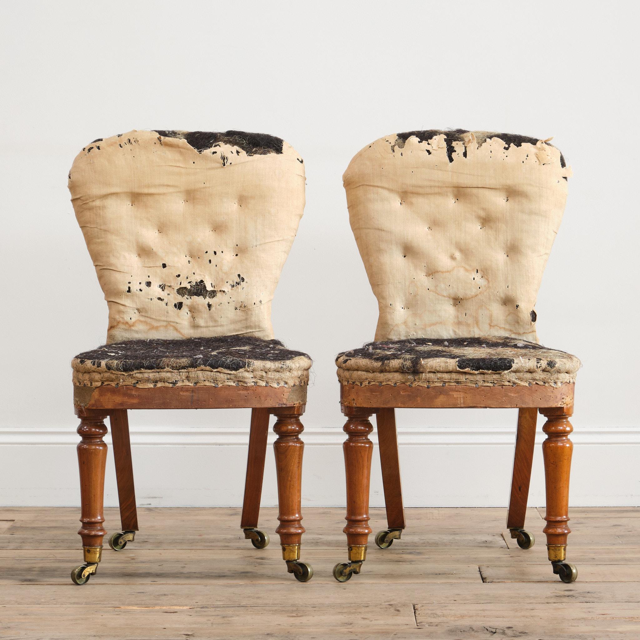 A superb pair of mid 19th century English slipper chairs. Raised on tall walnut turned front legs splayed rear legs and all with the original gilt brass Cope & Collinson brass casters. Both chairs retain the original innards which are firm and
