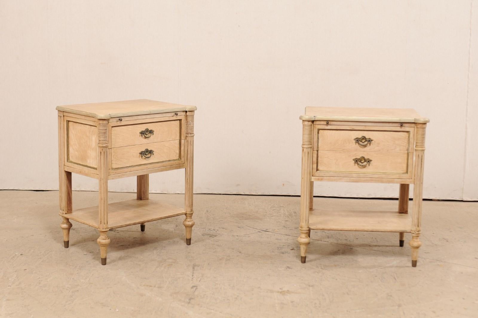 A pair of American nightstands from the mid-20th century. These vintage side chests, designed in French style, each feature rounded and fluted front side posts carved with horizontal ribbing and vertical fluting. Each front corner of the top has