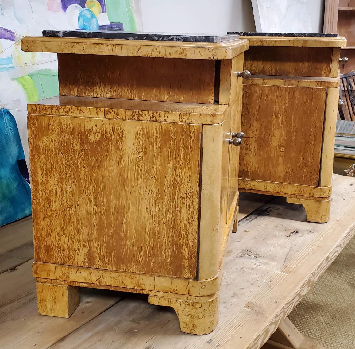 Pair of Art Deco marble top bedside end tables. Single drawer over cupboards on bracket feet. Lovely design and function that will make a excellent addition to just about any bedroom. Made of Birdseye Maple. Circa 1970. 
Measure: 24” H, 23.5” W,