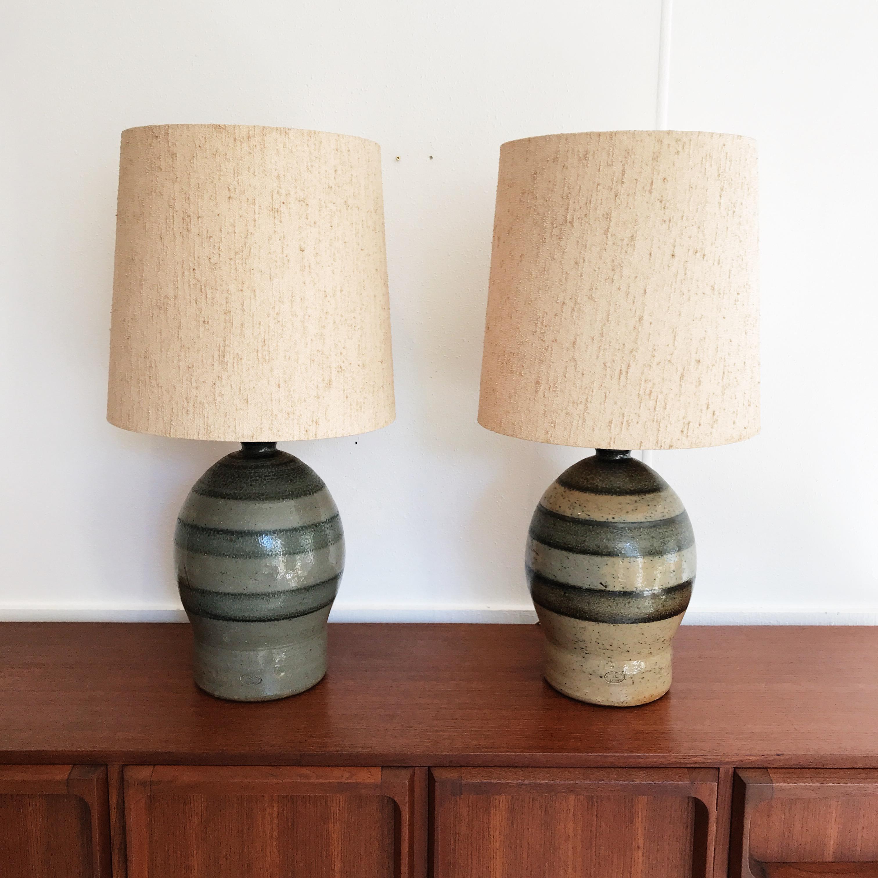 Extra large, odd couple pair of mid-20th century, water dispenser style table lamps, by renowned Australian potters, Bendigo Pottery, established 1958. 

Original and amazing, period correct, textured shades are included.

Without shade and