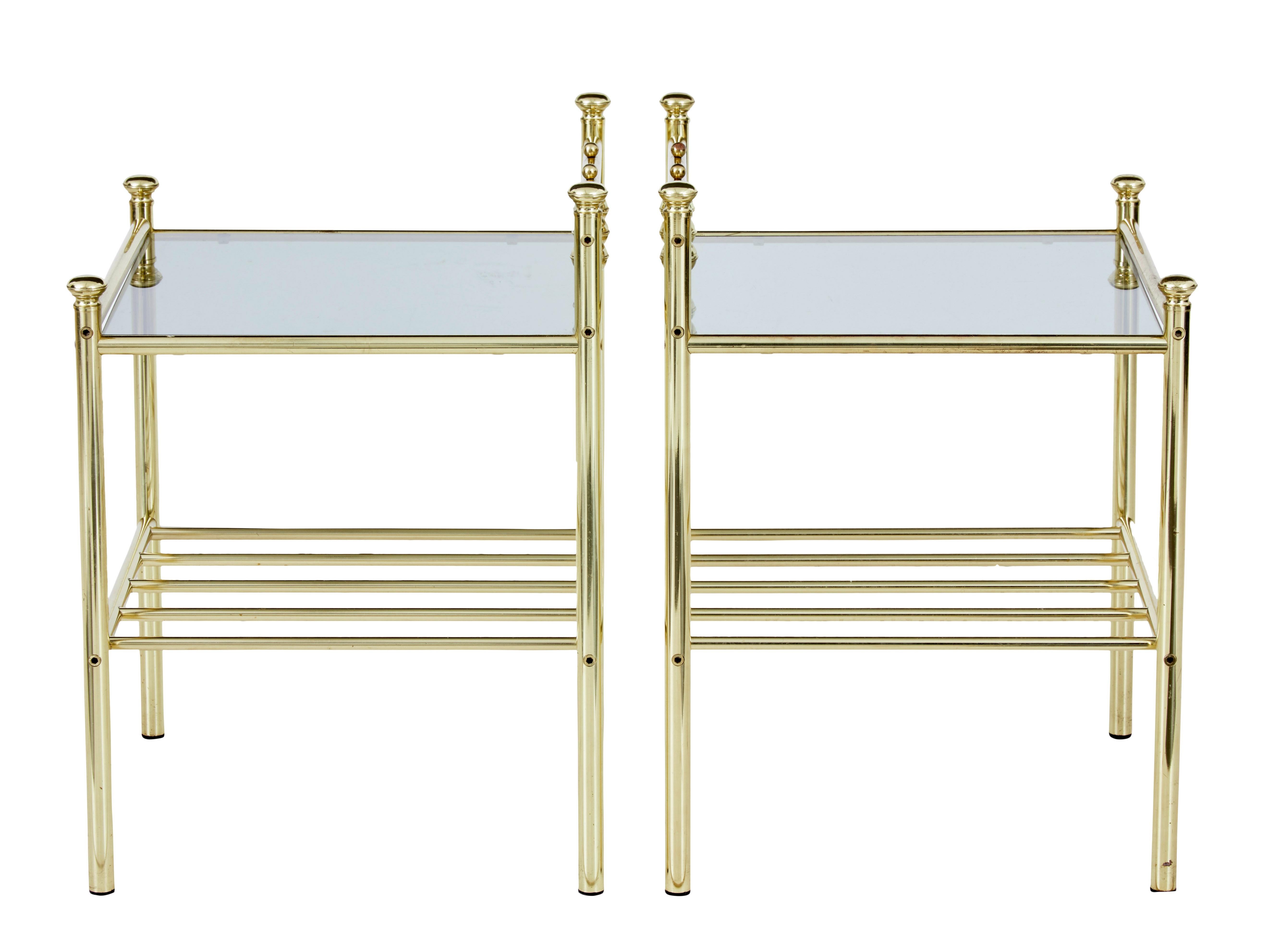 Pair of mid-20th century brass glass top occasional tables, circa 1960.

Pair of useful brass lamp / side tables. Brass spindles. With smoked glass top with lower open shelf.

Minor surface marks.