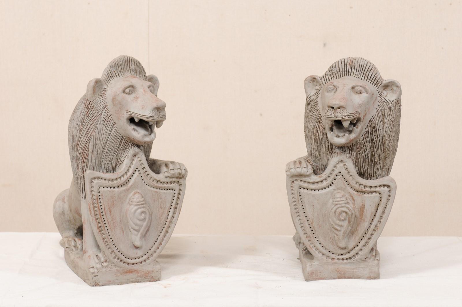 Indien Paire de lions coloniaux britanniques du milieu du 20e siècle en terre cuite avec bouclier en vente