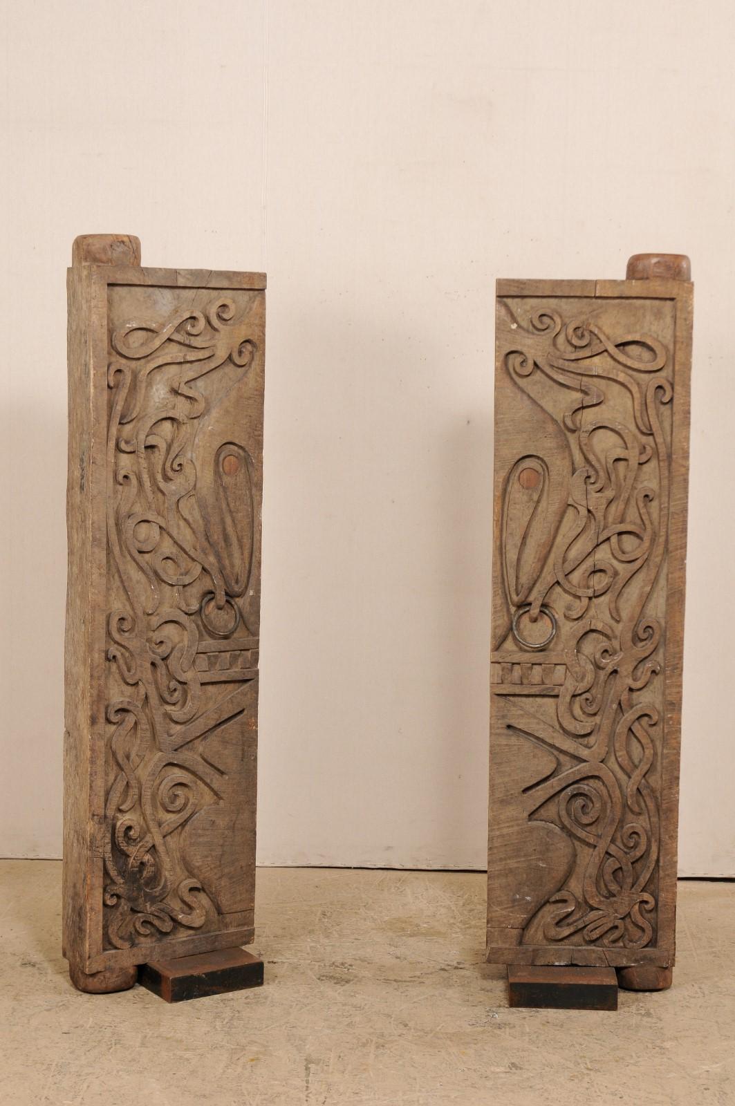 Une paire de portes en bois sculpté à la main de Bornéo sur des bases en fer personnalisées, milieu du 20e siècle. Cette paire de portes vintage de l'île de Bornéo est de belle taille, avec une épaisseur d'environ 5,75 pouces, et présente des