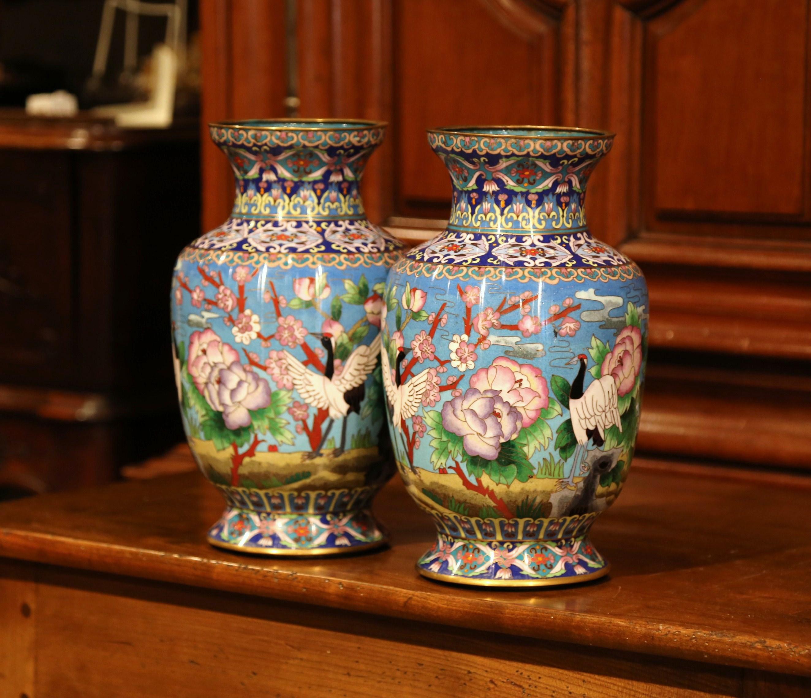 Decorate a mantel with this colorful pair of vases; created in China circa 1960, each vase with cloisonne technique (decorative work in which enamel, glass, or gemstones are separated by strips of flattened wire placed edgeways on a metal backing),