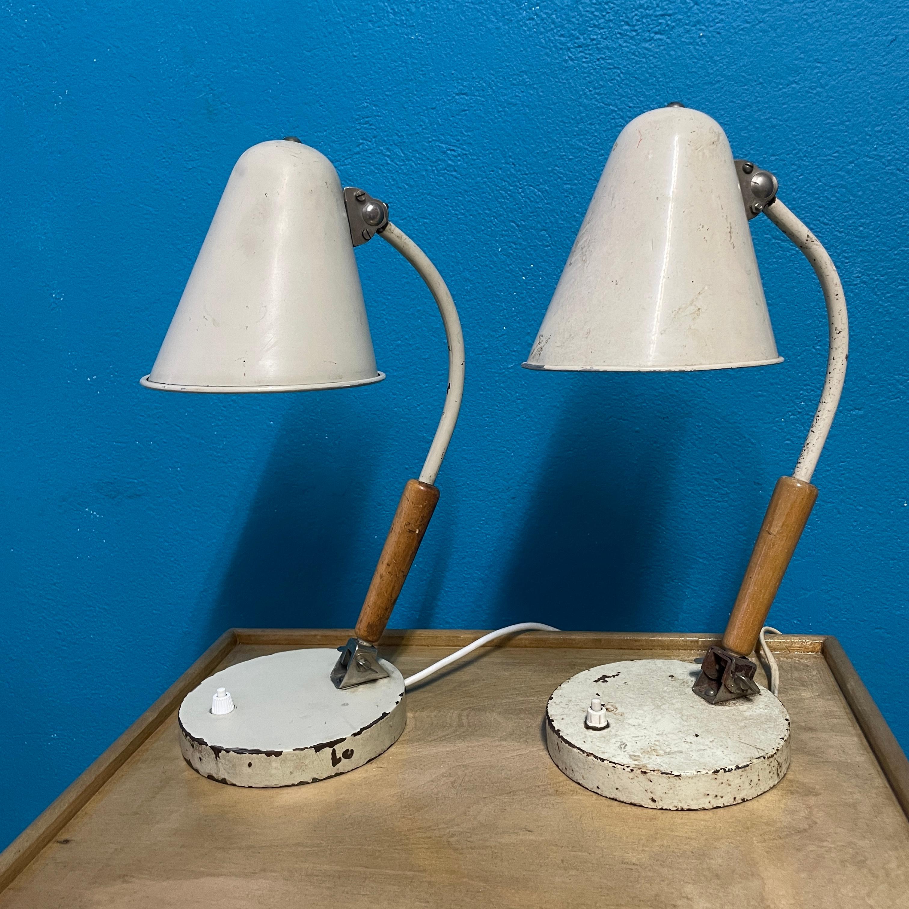 A pair of Desk Lamps, model 81408, designed by Paavo Tynell for Idman. 
Beige colored metal arm with teak-wood detail. Adjustable arm and shade. 
Manufacturer's marking 
