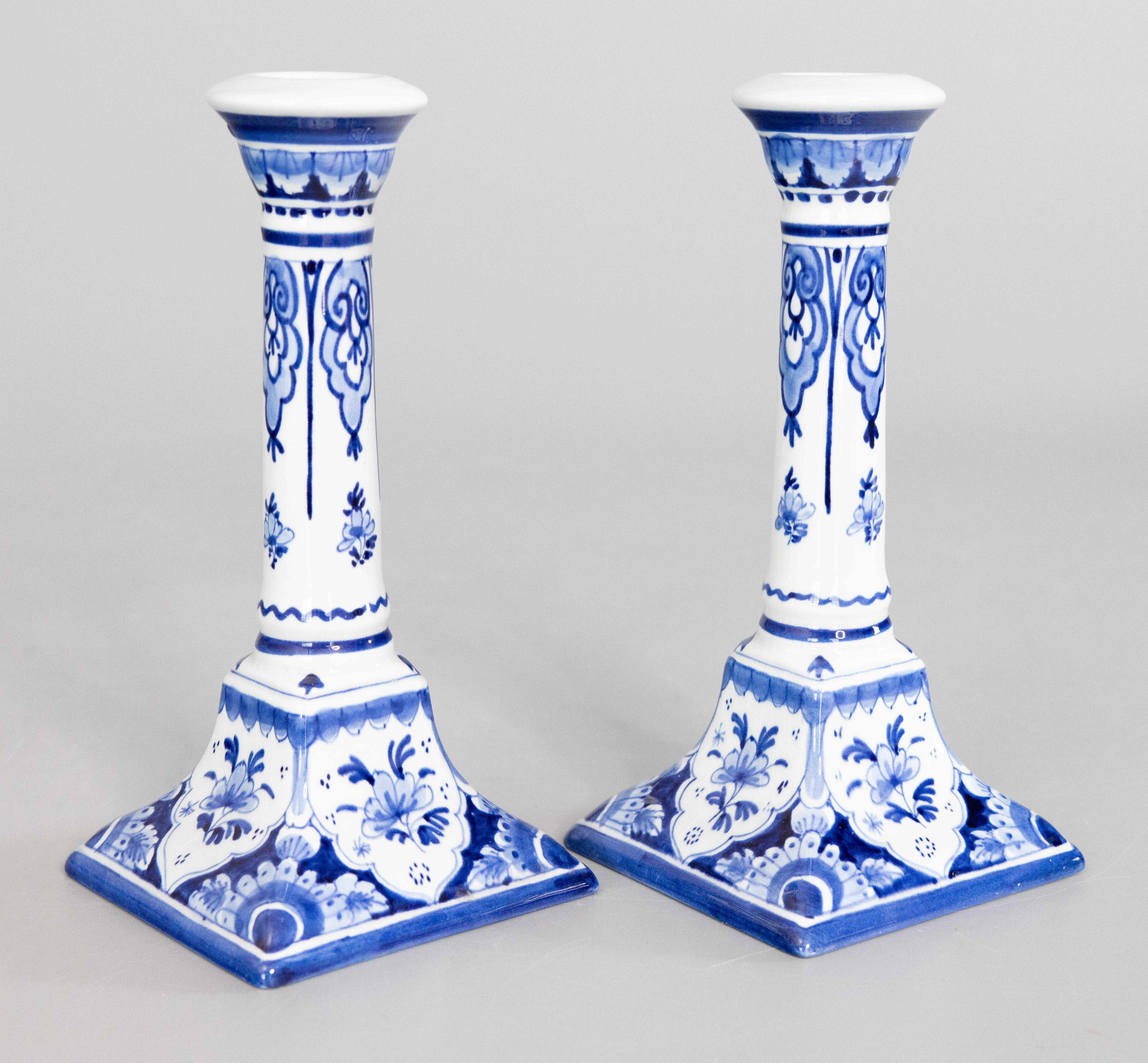 Una bella coppia di candelieri in maiolica olandese di Delft della metà del secolo. Marchio del fabbricante sul retro. Questi raffinati candelieri sono dipinti a mano con un bellissimo disegno floreale nei tradizionali colori Delft del blu cobalto e
