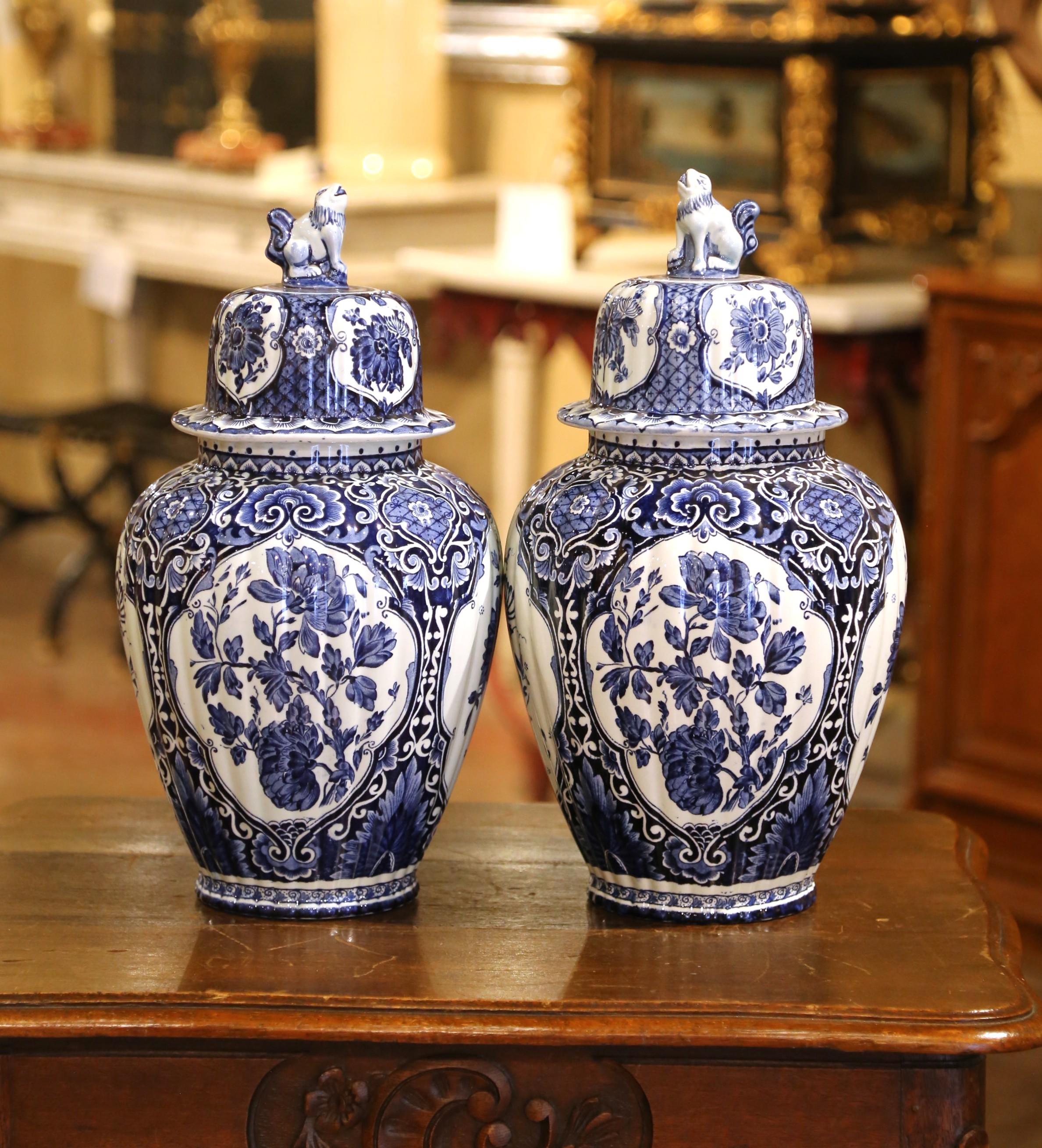 Stellen Sie dieses elegante Paar antiker Keramik-Ingwergläser auf einen Kaminsims oder eine Konsole im Eingangsbereich. Die um 1960 in Holland hergestellten traditionellen blau-weißen Krüge haben eine runde Form und einen konischen Deckel, der oben