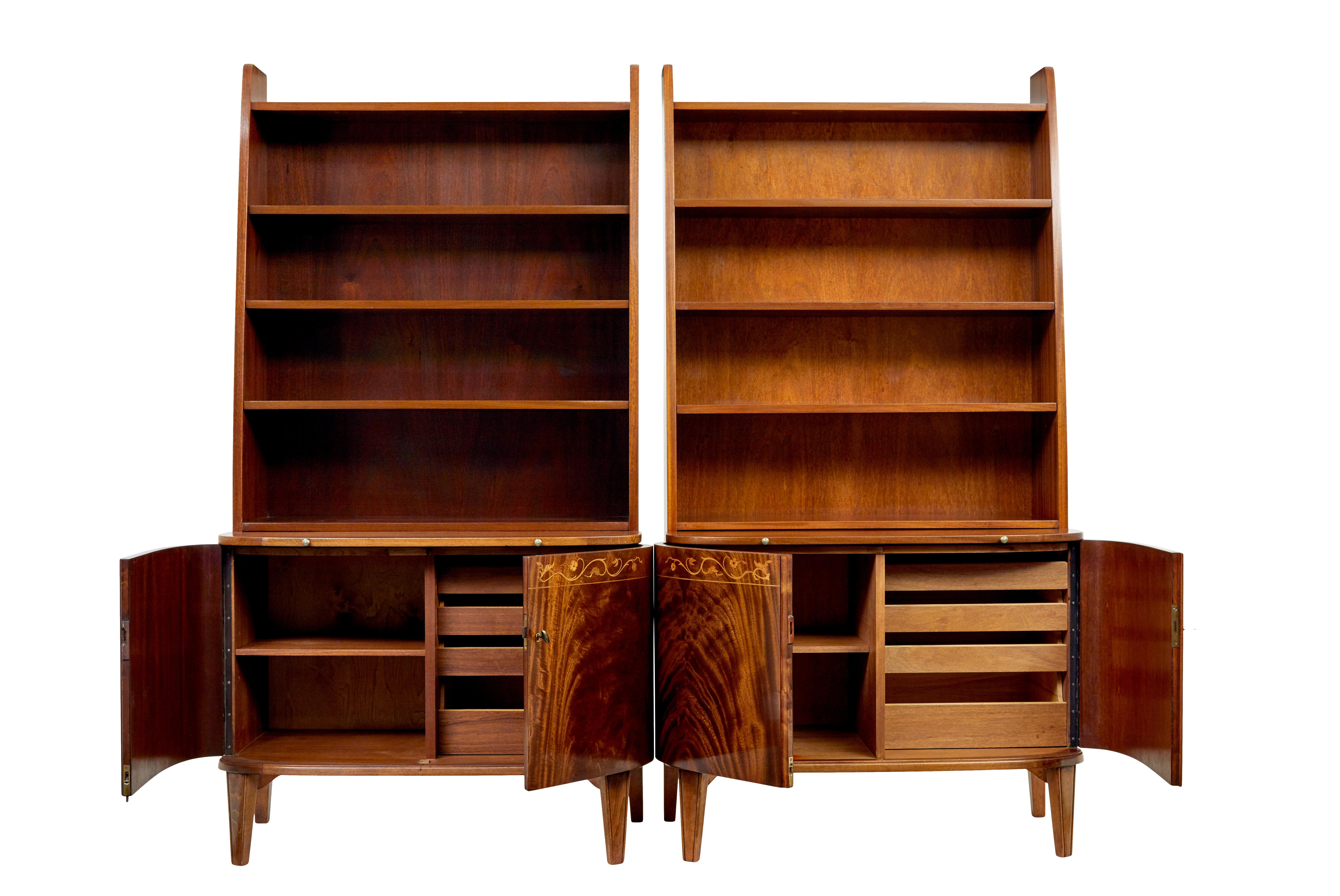 Near pair of flame mahogany bookcase units circa 1950.

Near pair because they are the same model and design, but slightly different colours and veneers used.

1 piece units, top section with 3 fixed shelves allowing 5 apertures for storage.  Each