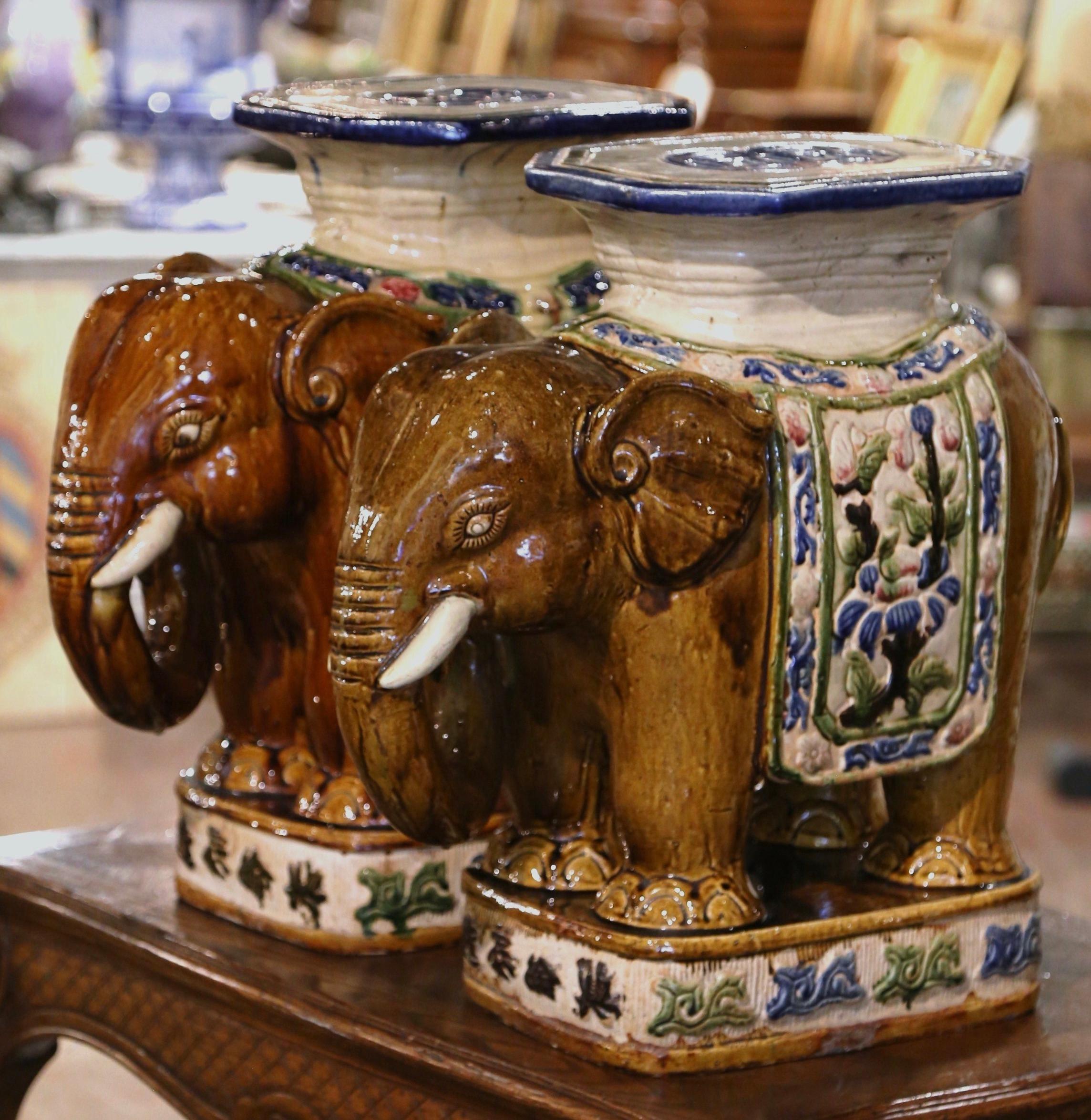 These colorful vintage porcelain garden seats were found in France. Crafted circa 1960, each large ceramic seating shaped as an elephant with his trunk lowered is heavily decorated in oriental finery; the colorful mammal has a rectangular seat at