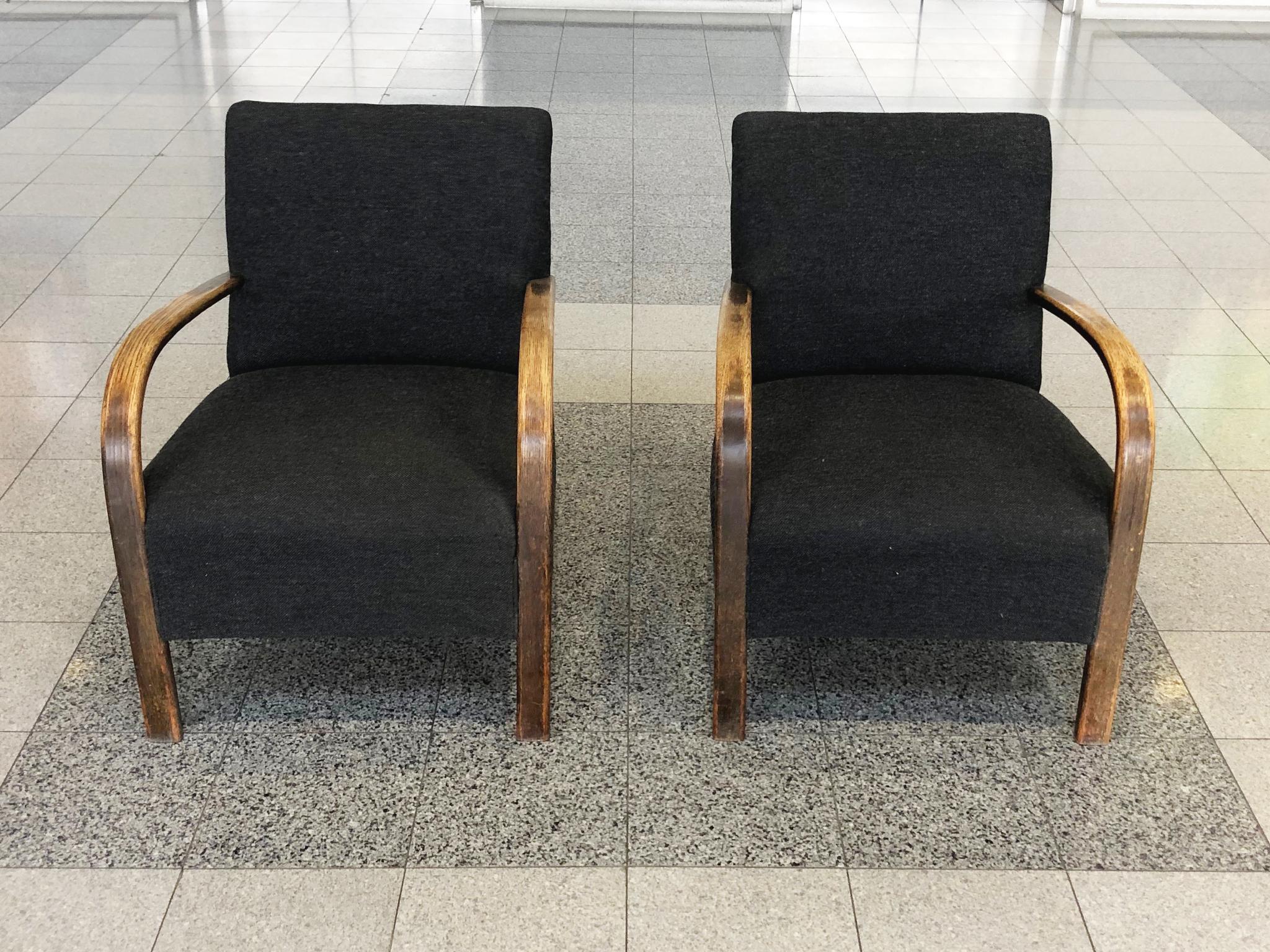 These exquisite Danish lounge chairs by Fritz Hansen were crafted in the 1950s. They are comprised of bent oak and later reupholstered in a black wool fabric. The bentwood arms have aged beautifully. We love their thin, elegant forms in comparison