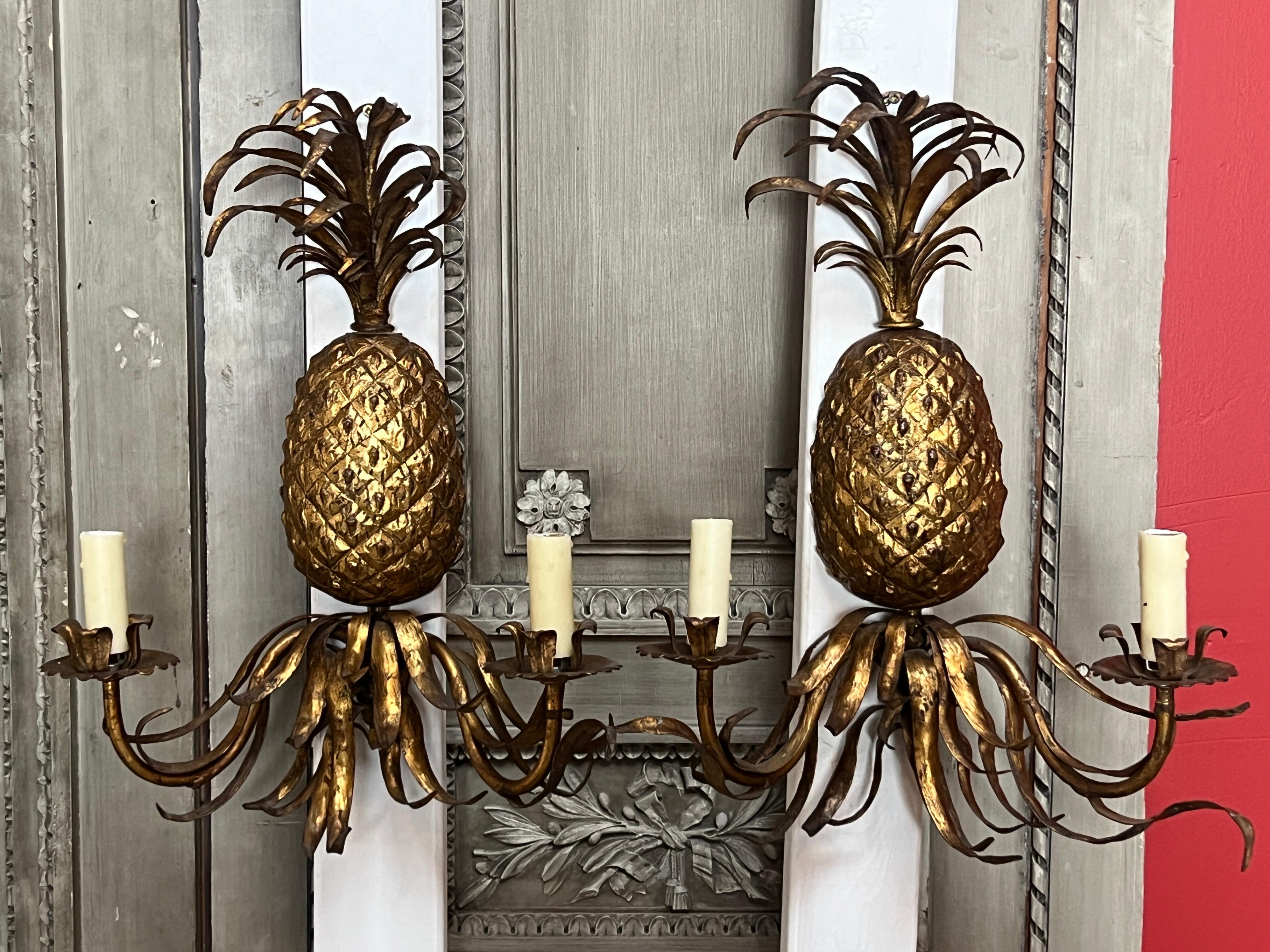 A pair of very decorative Italian Gilt iron scones with a pineapple motif.  
These two light wall lights are in a great old finish with a glazed gold finish. 
There is a matching chandelier available for a great dining room lighting suite.  