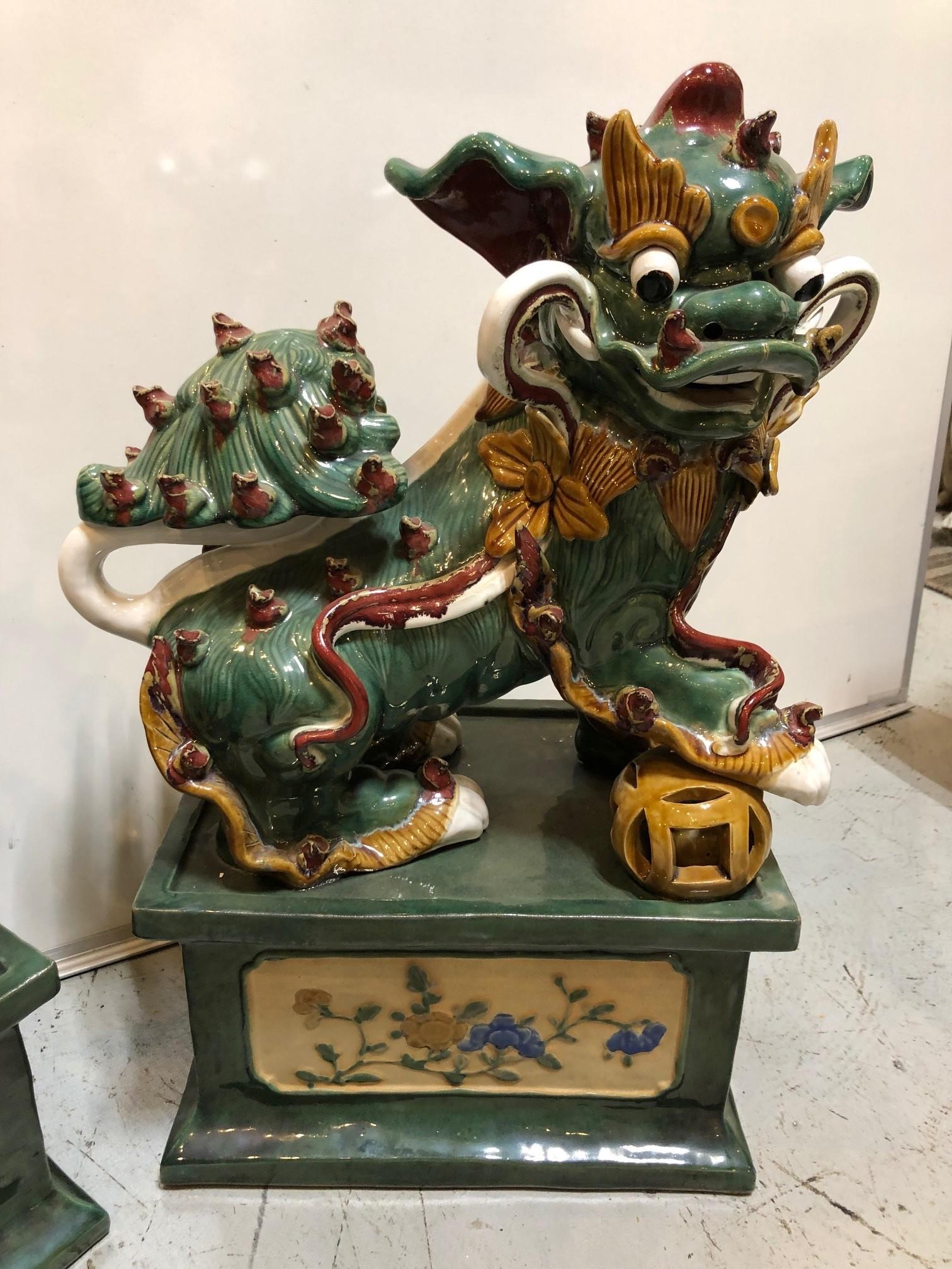 Pair of mid 20th century glazed terracotta foo dogs with a great colors. This is a good looking pair of Foo Dogs and a nice size for any room. Foo Dogs also known as Guardian Lions symbolize prosperity, success, and guardianship, placed at the