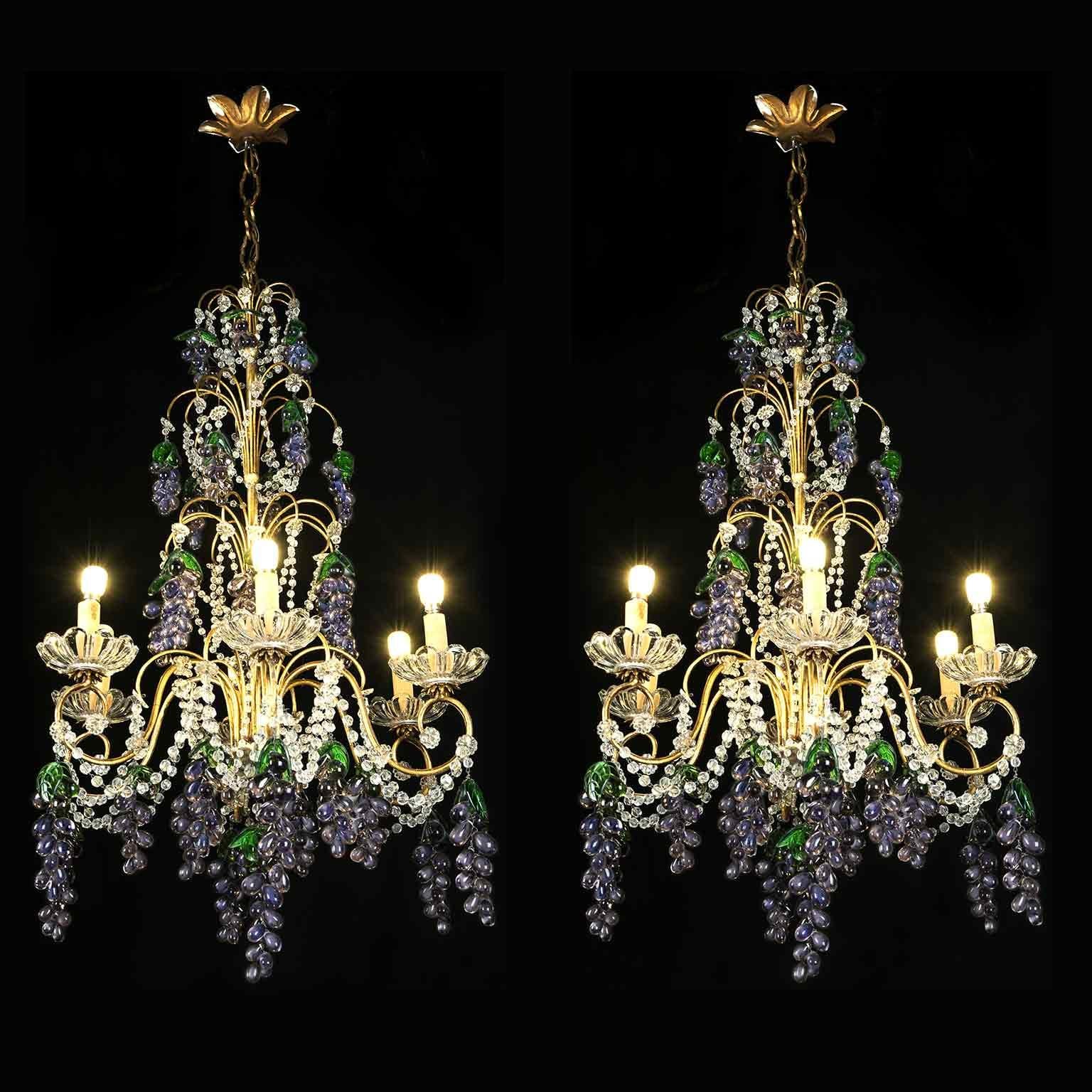 A pair of charming Italian gilt iron and clear crystal six-light chandeliers adorned with purple amethyst colored glass pendants from Murano, embellished with a multitude of fruit grapes pendants in colored glass. Each branch has one light and
