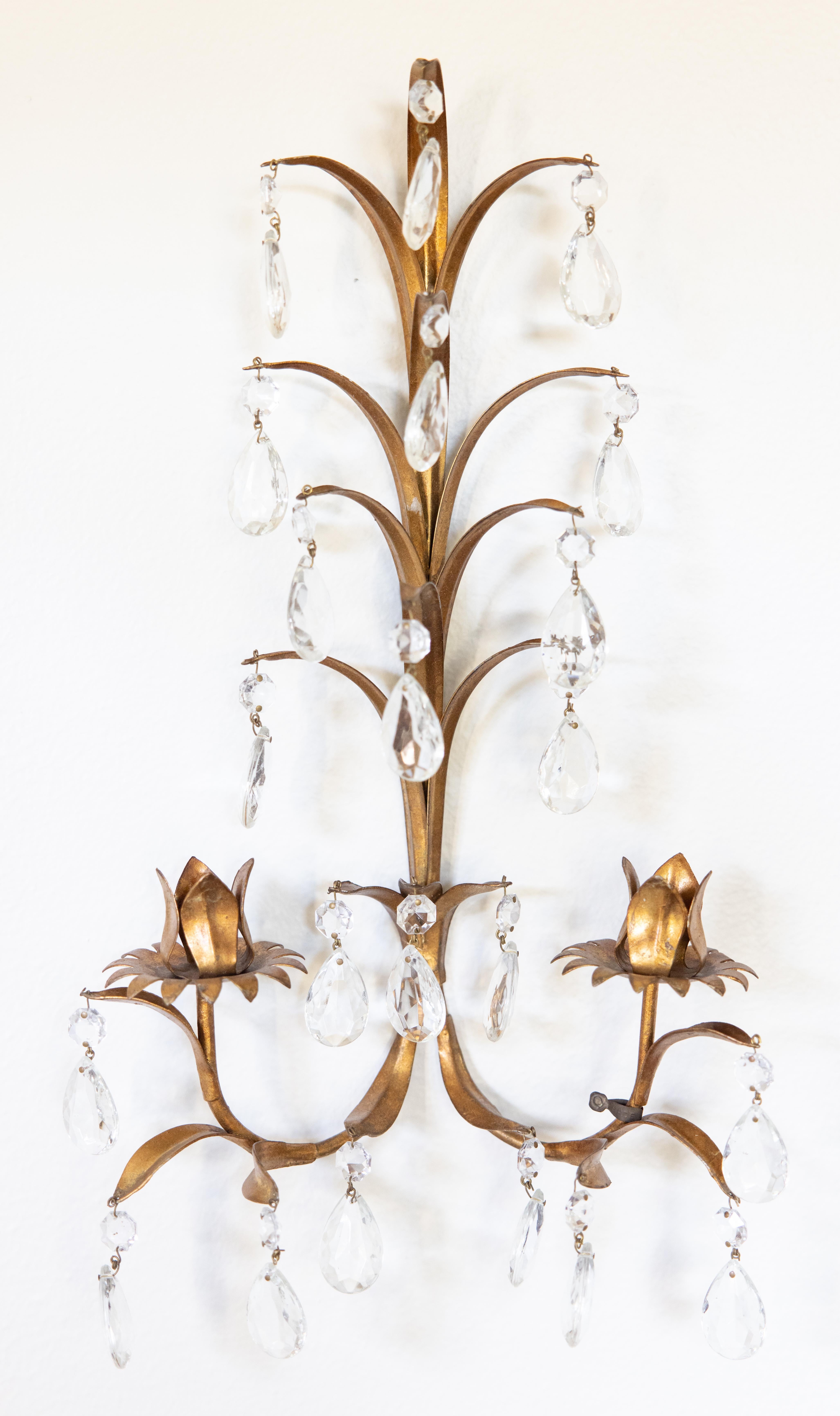 A gorgeous Mid-20th Century pair of Italian gilded tole and crystal two arm wall candle sconces. 