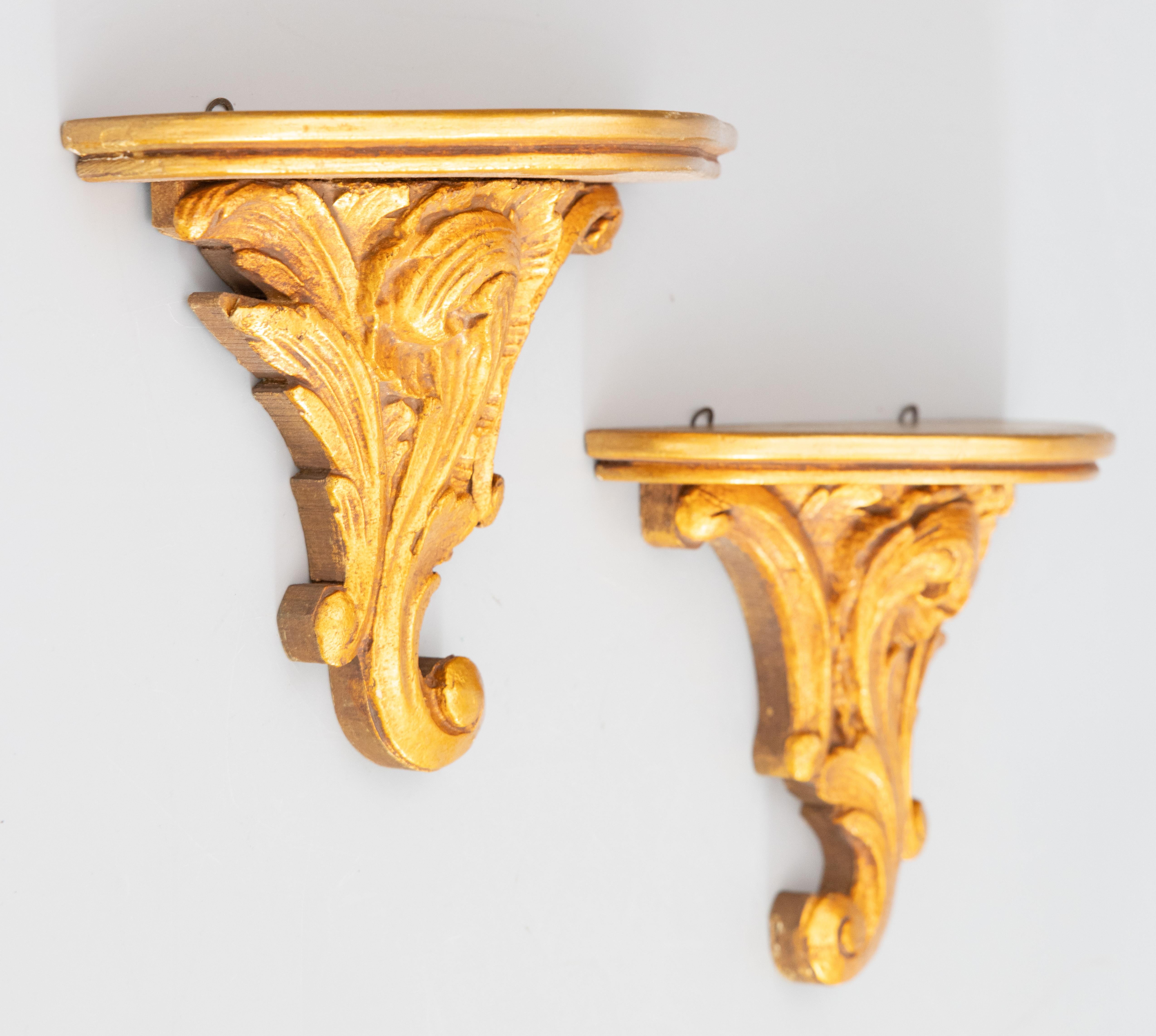 A lovely pair of vintage Italian gilded wood and gesso wall brackets shelves, circa 1950. These stunning brackets are decorated with scrolling leaves in a beautiful gilt patina. They are perfect for displaying decorative collectibles or fabulous on