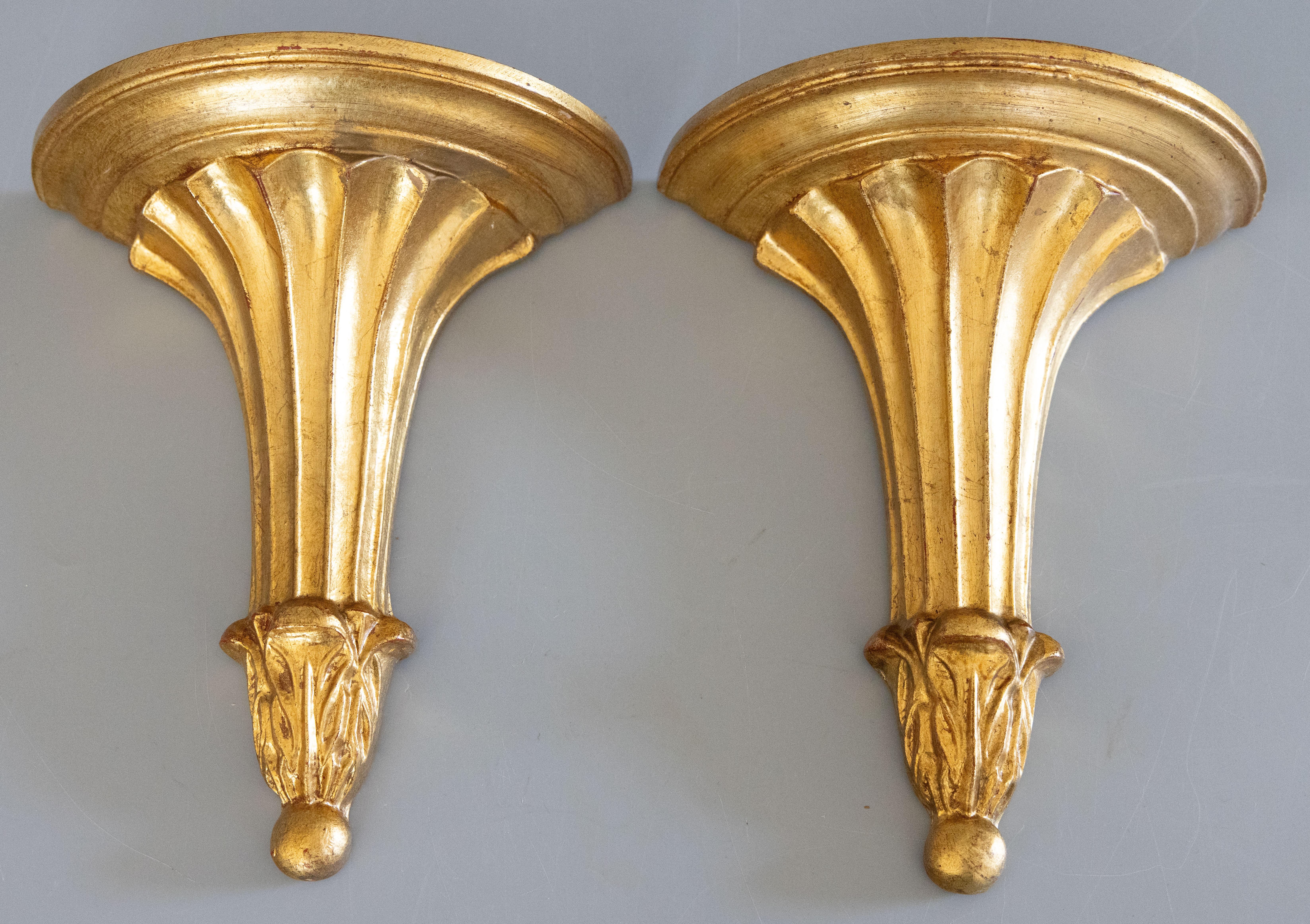 A stunning pair of vintage Mid-Century Neoclassical style Italian Florentine gilded wood wall brackets or shelves. These gorgeous brackets have a stylish fluted design with a lovely gilt patina. They are perfect for displaying decorative