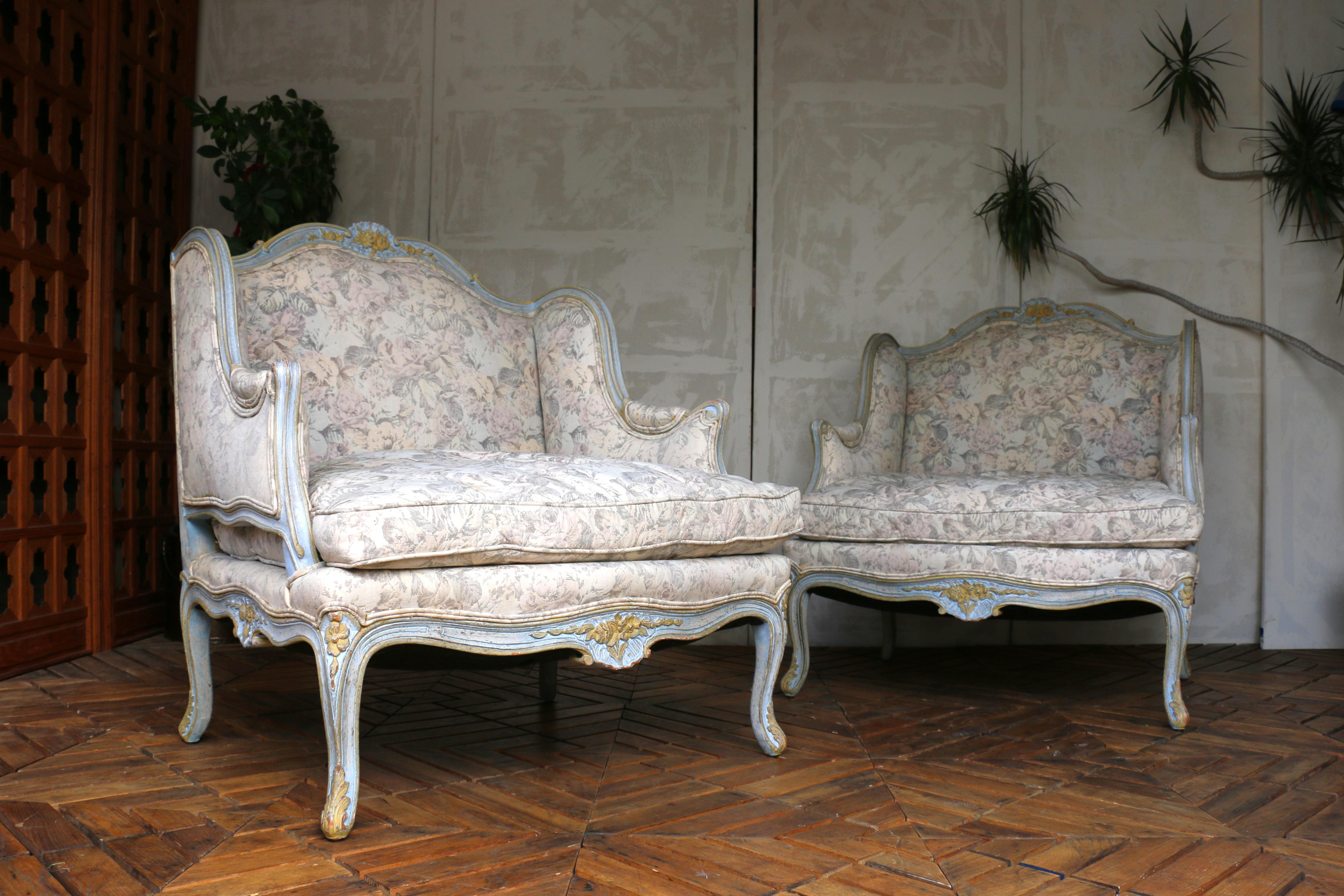 Évoquant le romantisme de la France du milieu du XXe siècle, cette paire exquise de fauteuils bergère à dossier ailé de style Louis XV capture l'essence de l'élégance intemporelle. Fabriquée en bois massif, chaque chaise présente de délicats motifs