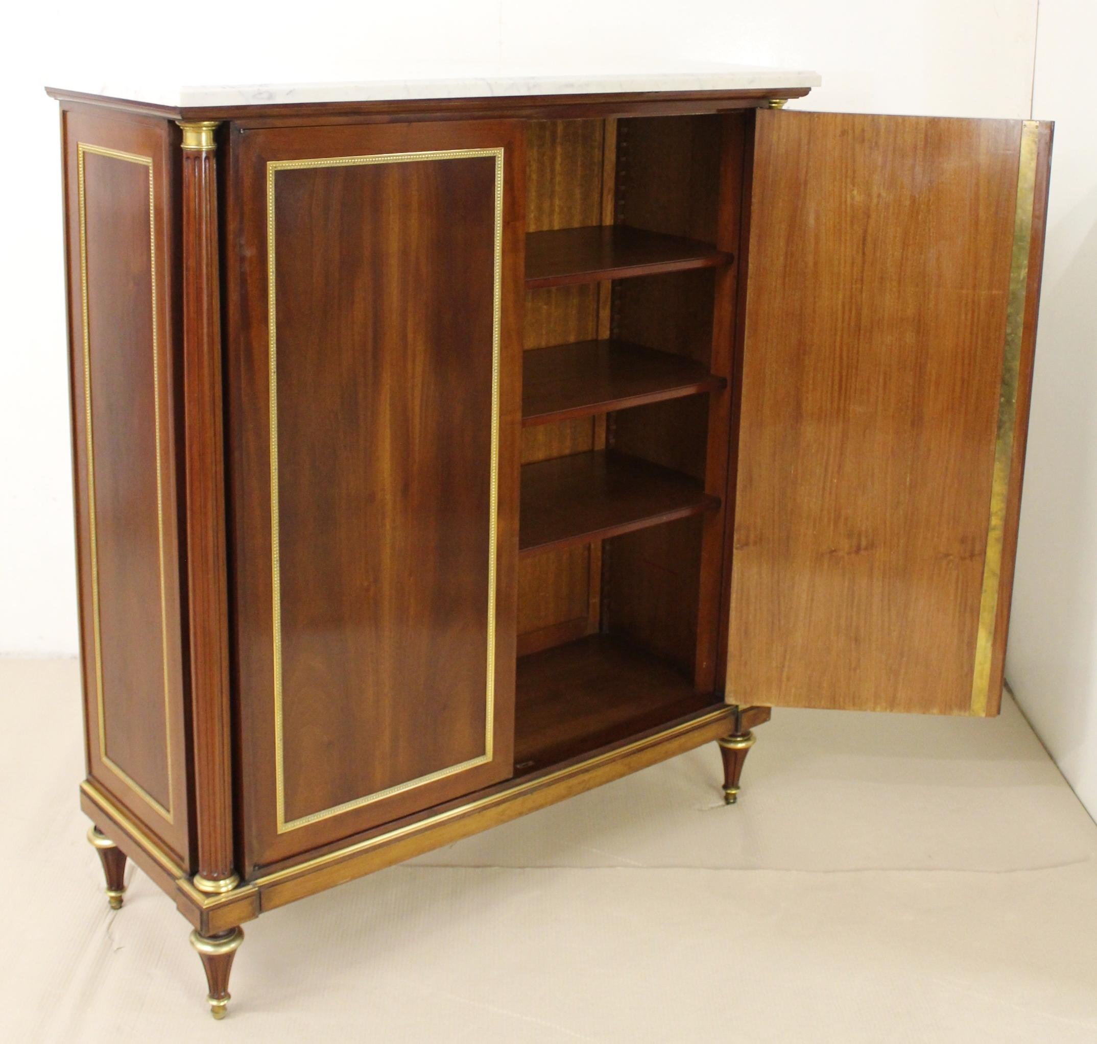 A splendid pair of French mahogany side cabinets of the finest quality. Exceptionally well made by the renowned Parisian cabinet maker Maurice Rinck. Constructed in a high grade of dense mahogany timber and fitted with white marble tops. Each has a