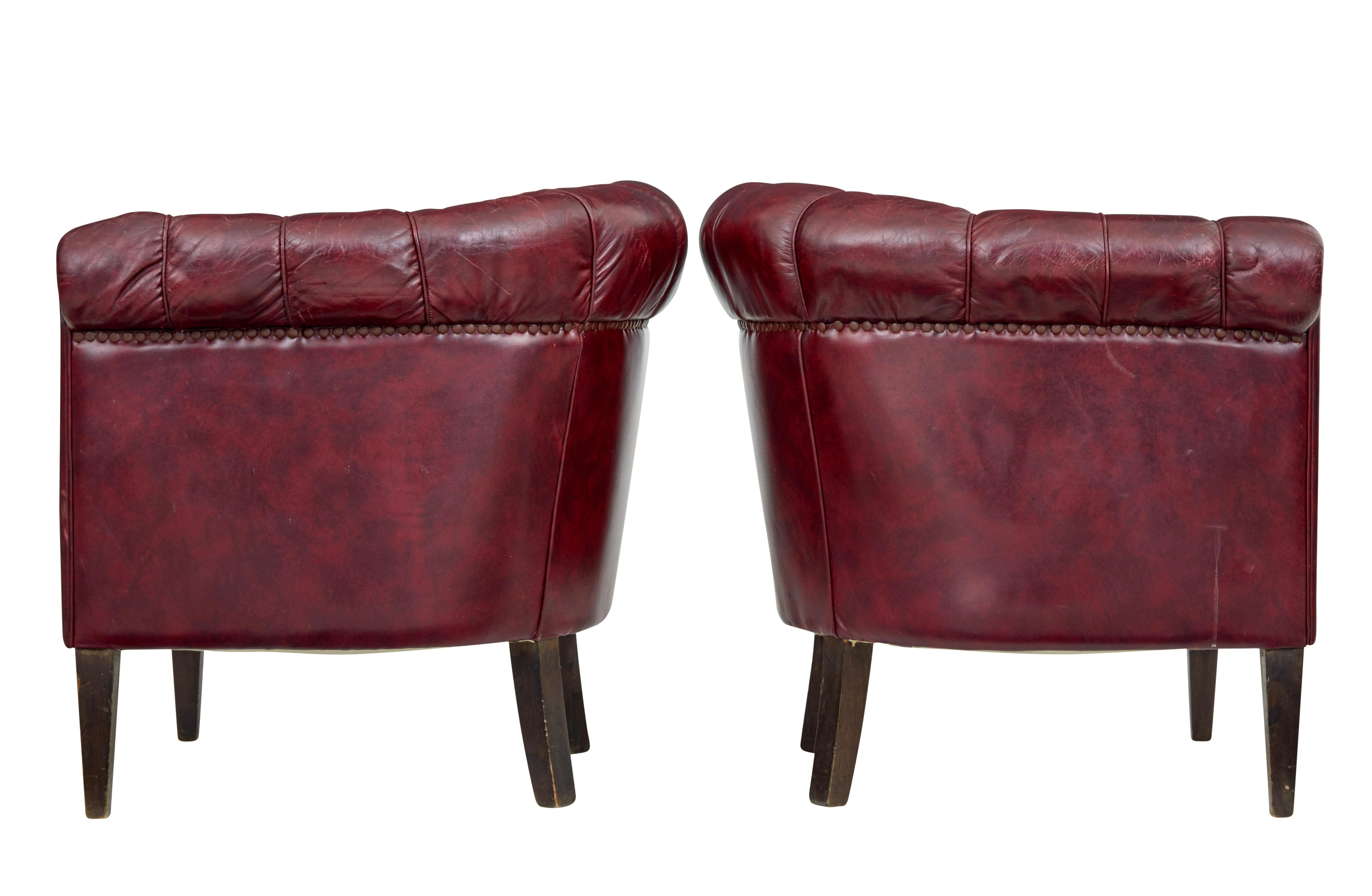 Good quality pair of leather armchairs circa 1950.

Over stuffed arms and button back design make these a very comfortable pair of chairs.  Deep red leather arranged with piping and button work.

Leather in very good condition for age with very