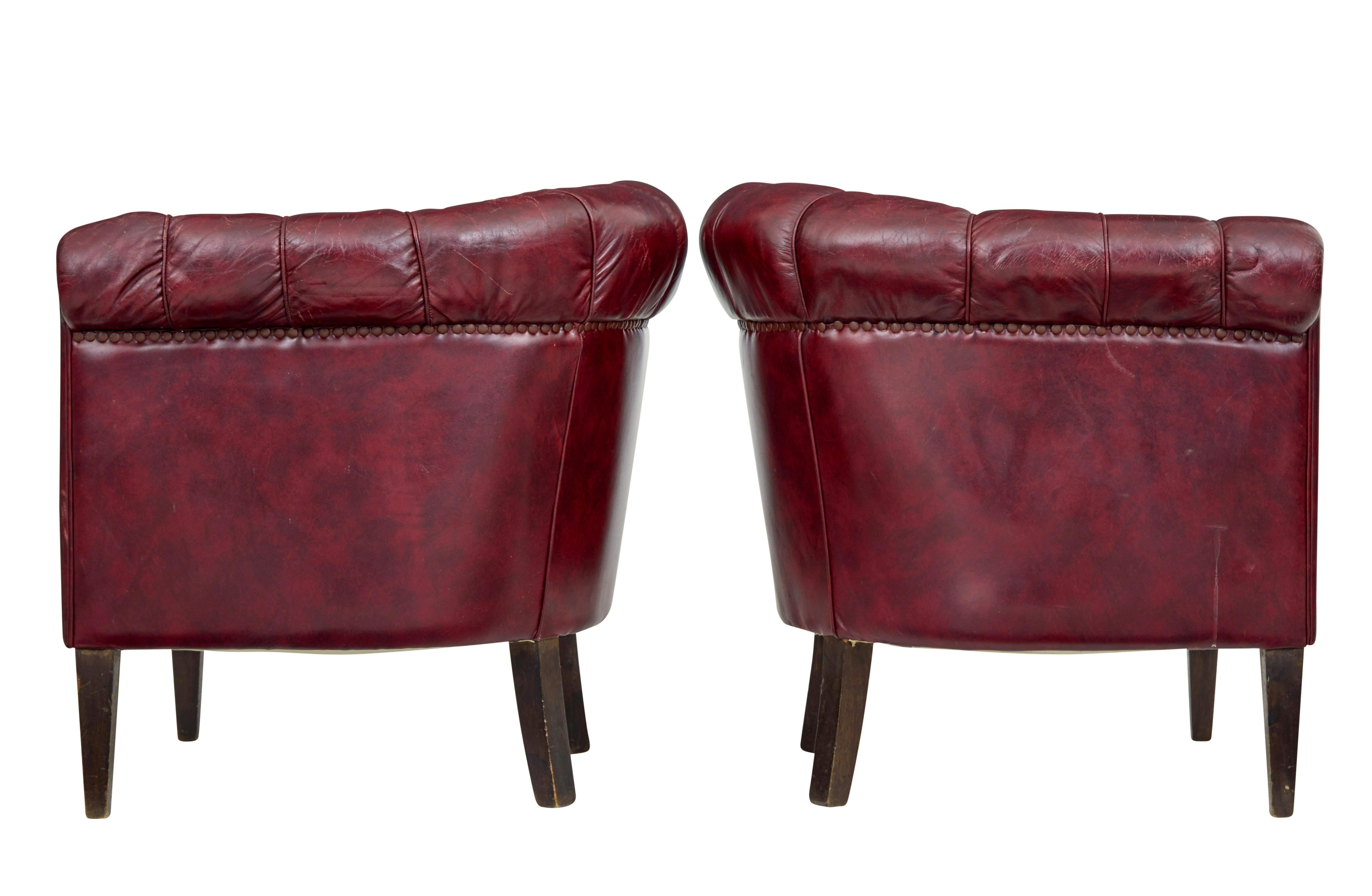 Good quality pair of leather armchairs circa 1950.

Over stuffed arms and button back design make these a very comfortable pair of chairs.  Deep red leather arranged with piping and button work.

Leather in very good condition for age with very