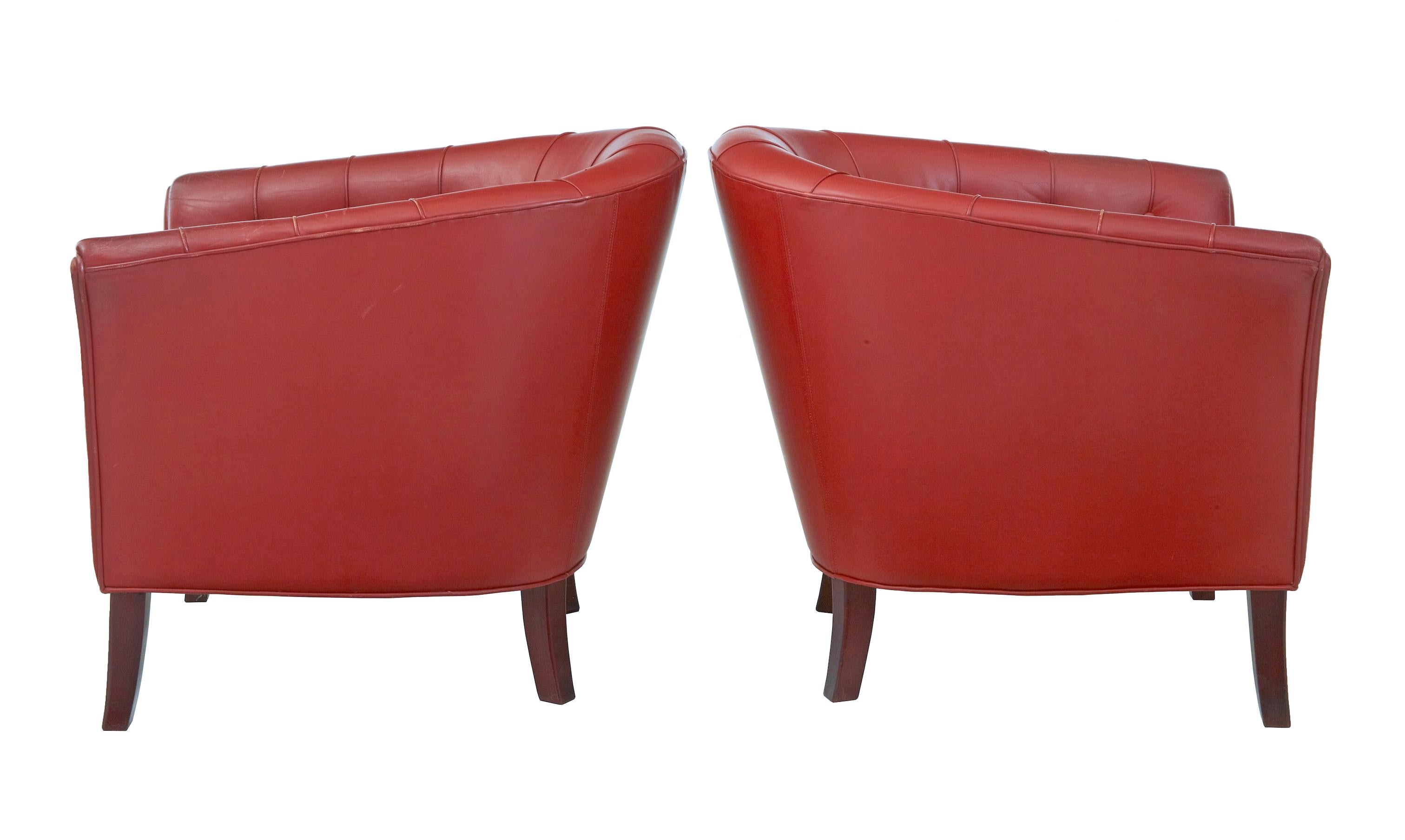 Pair of mid-20th century Scandinavian leather club armchairs, circa 1970.

Very comfortable and elegantly shaped pair of armchairs, upholstered in rusty red leather with button back detailing and piping.

Standing on dark stained tapering