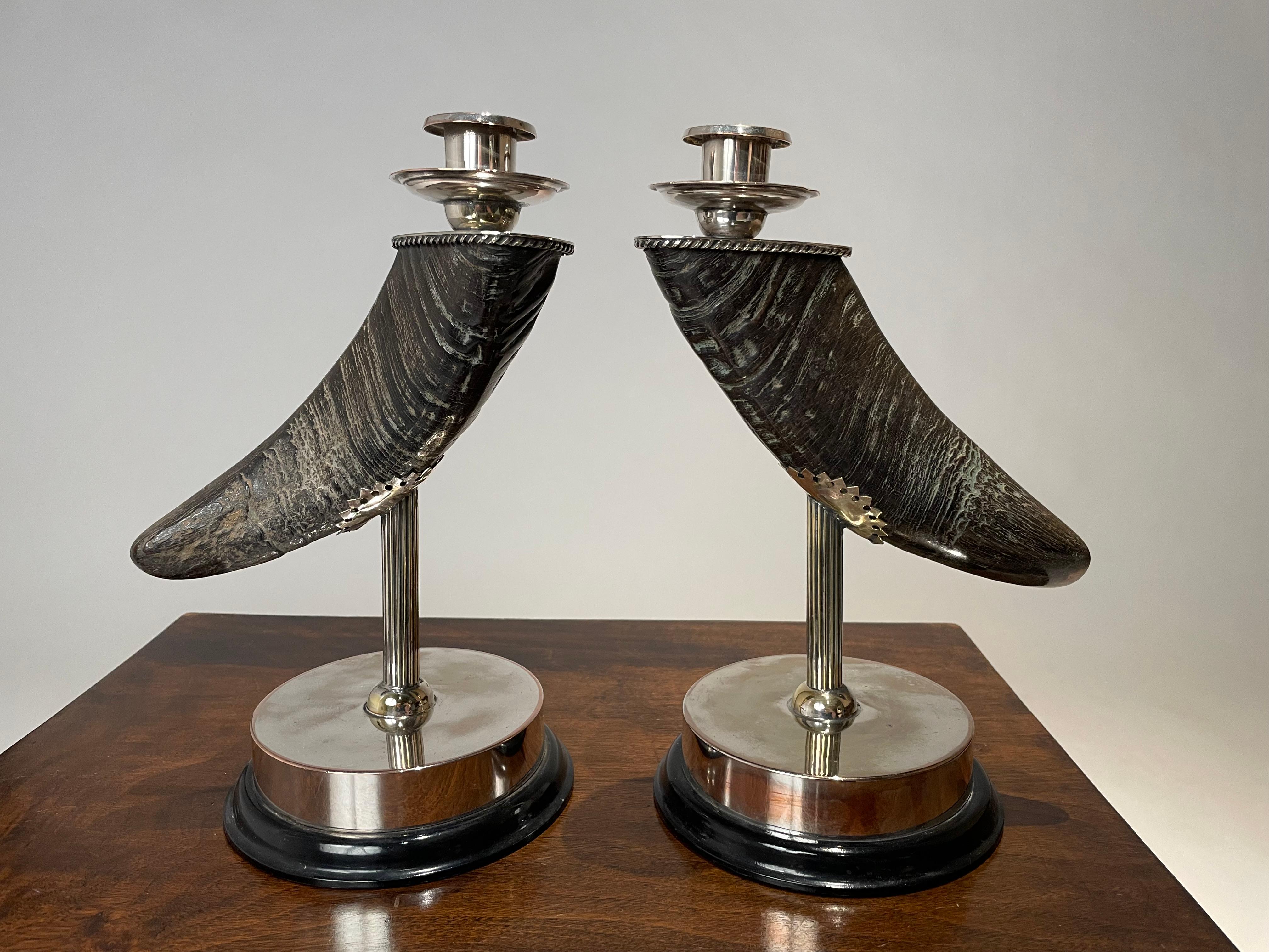 Great looking pair of silver plated horn candlesticks with black lacquered wood bases. The horns, possibly water buffalo, have a wonderful color and patina. Mounted on silver plated columns supported by circular black lacquer bases. An unusual and