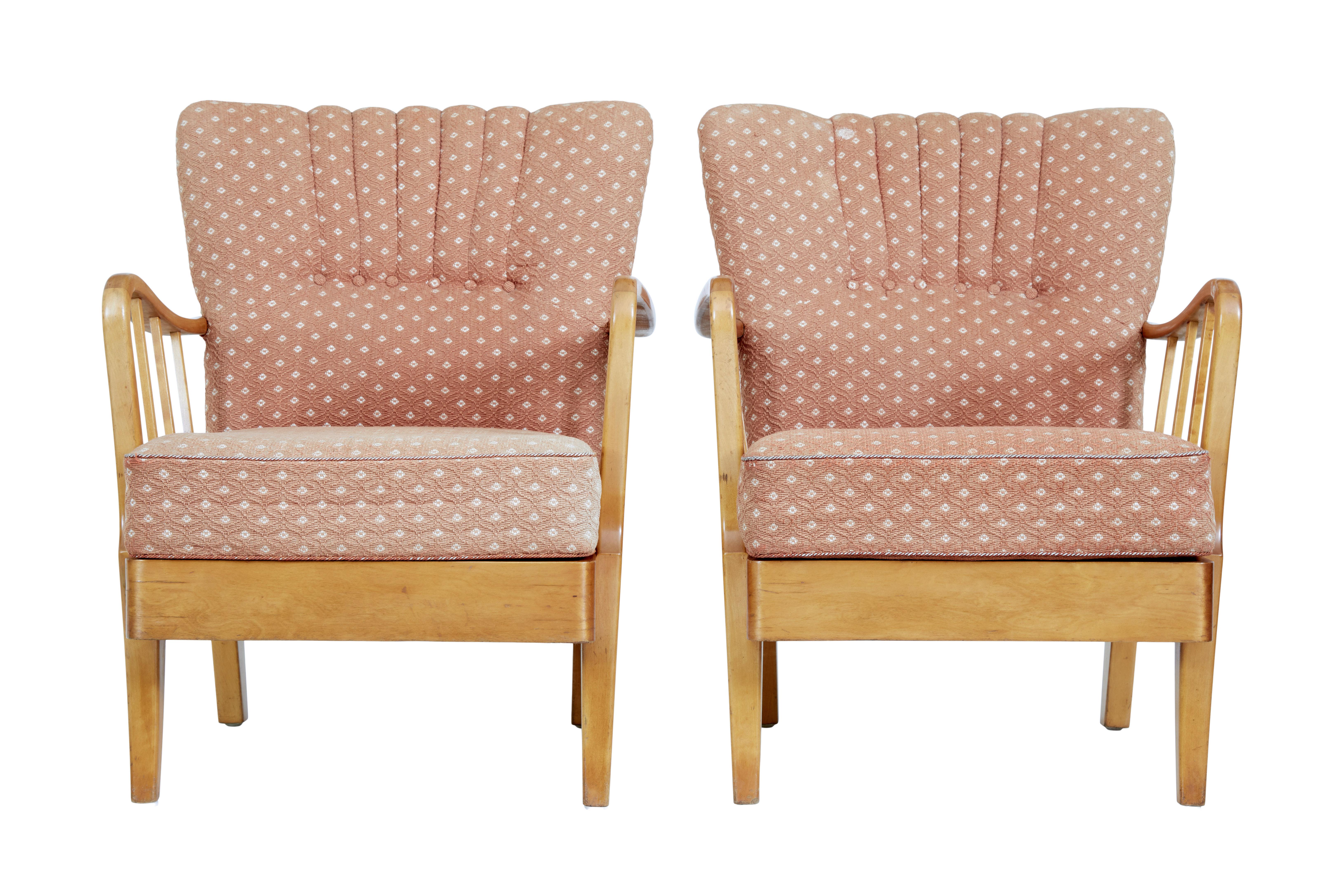 Pair of mid 20th century Swedish birch armchairs circa 1950.

Good quality pair of mid century armchairs, with Art Deco influenced scalloped back rest, and removable seat cushion. Shaped showframe arms. Standing on tapering legs.

Original