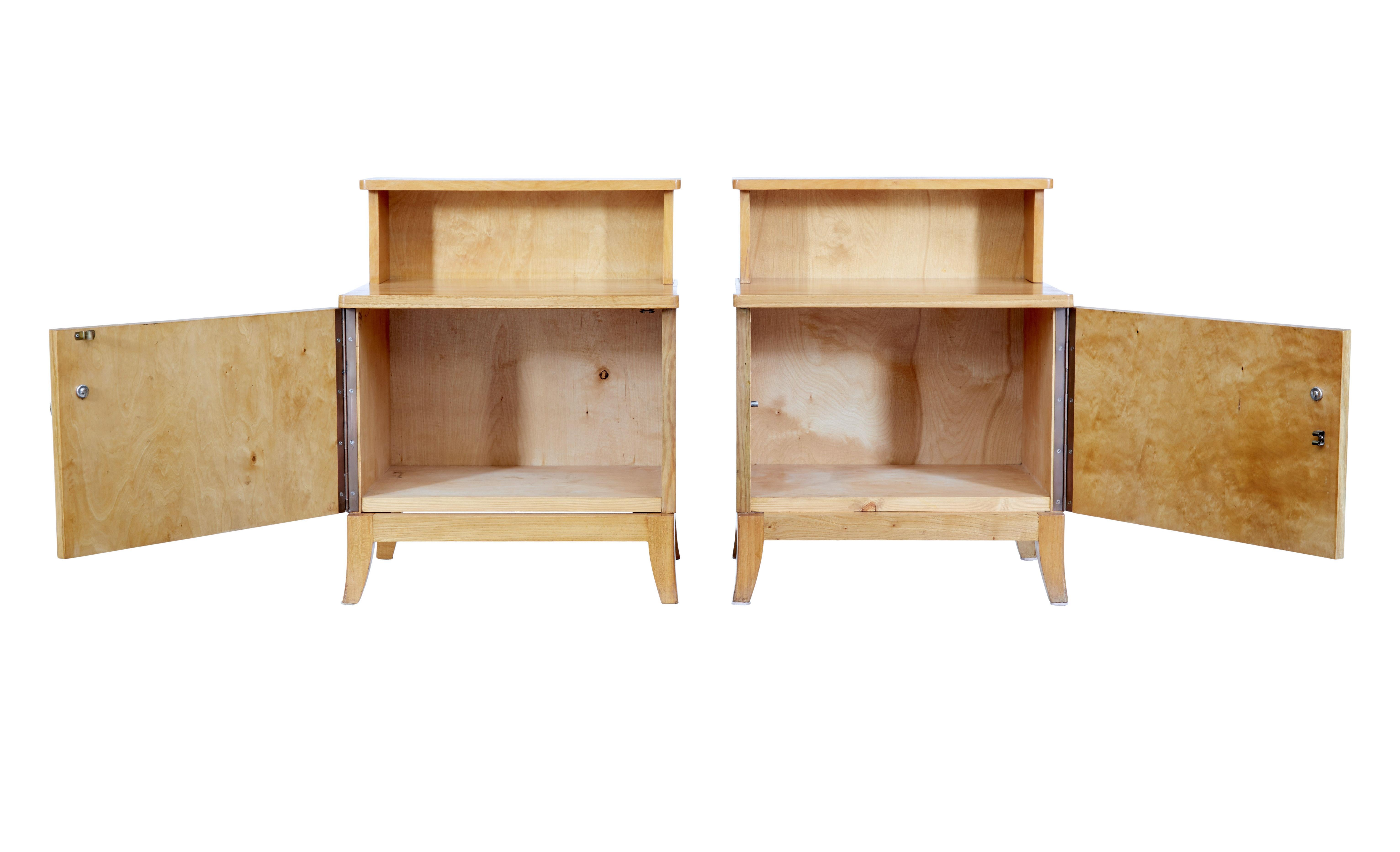 Pair of mid 20th century Swedish elm bedside tables circa 1950.

Pair of elegant Swedish bedside cupboards made in elm. Top shelf which forms a gallery for the main top surface. Single door cupboards fitted with a brass ring handle open to reveal