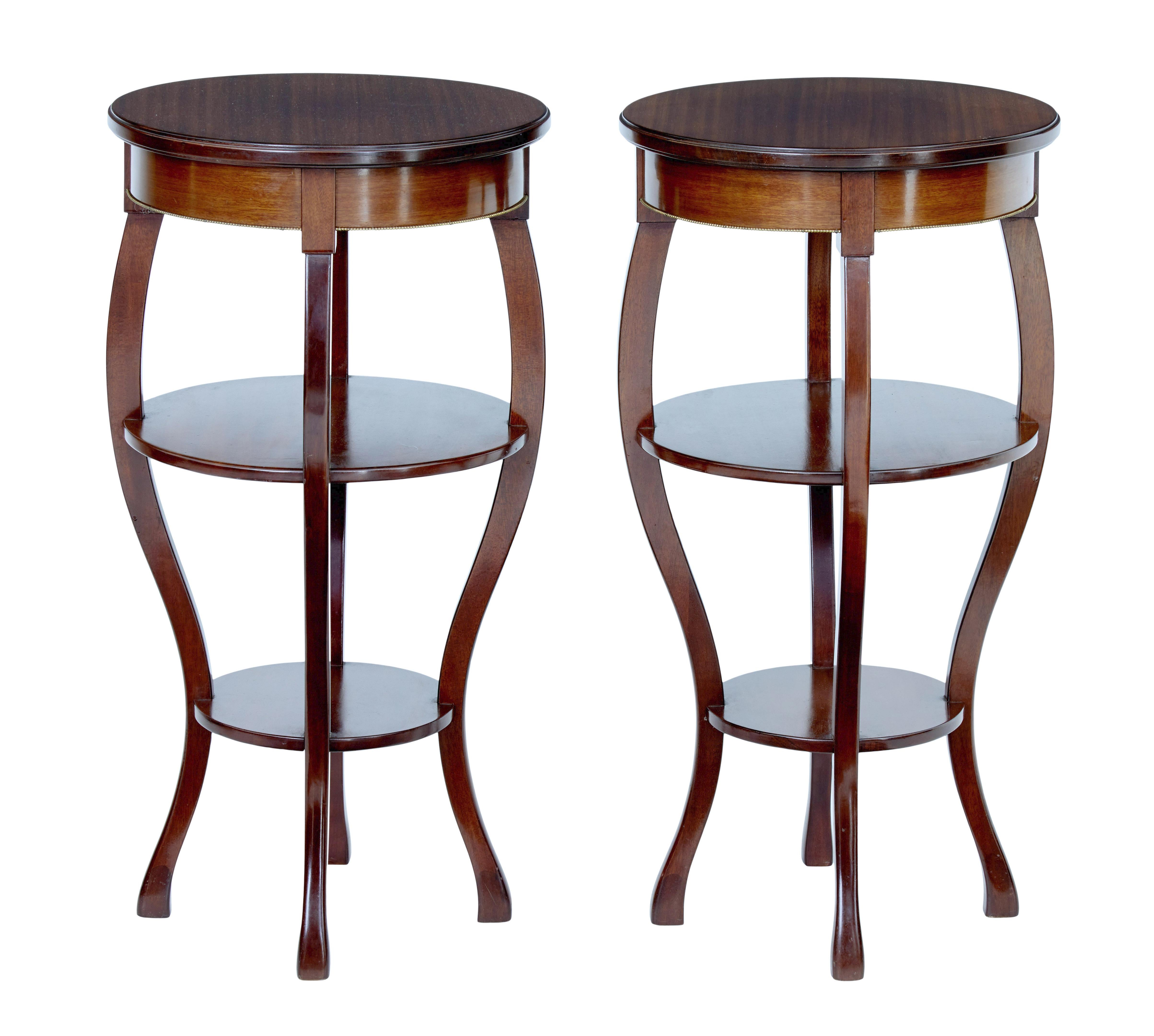 Good quality pair of occasional tables, circa 1950.

Made in mahogany and very much in the Empire taste. Circular tops with brass beading detail to the frieze. Standing on 4 sabre legs with a further 2 circular shelves supported between the