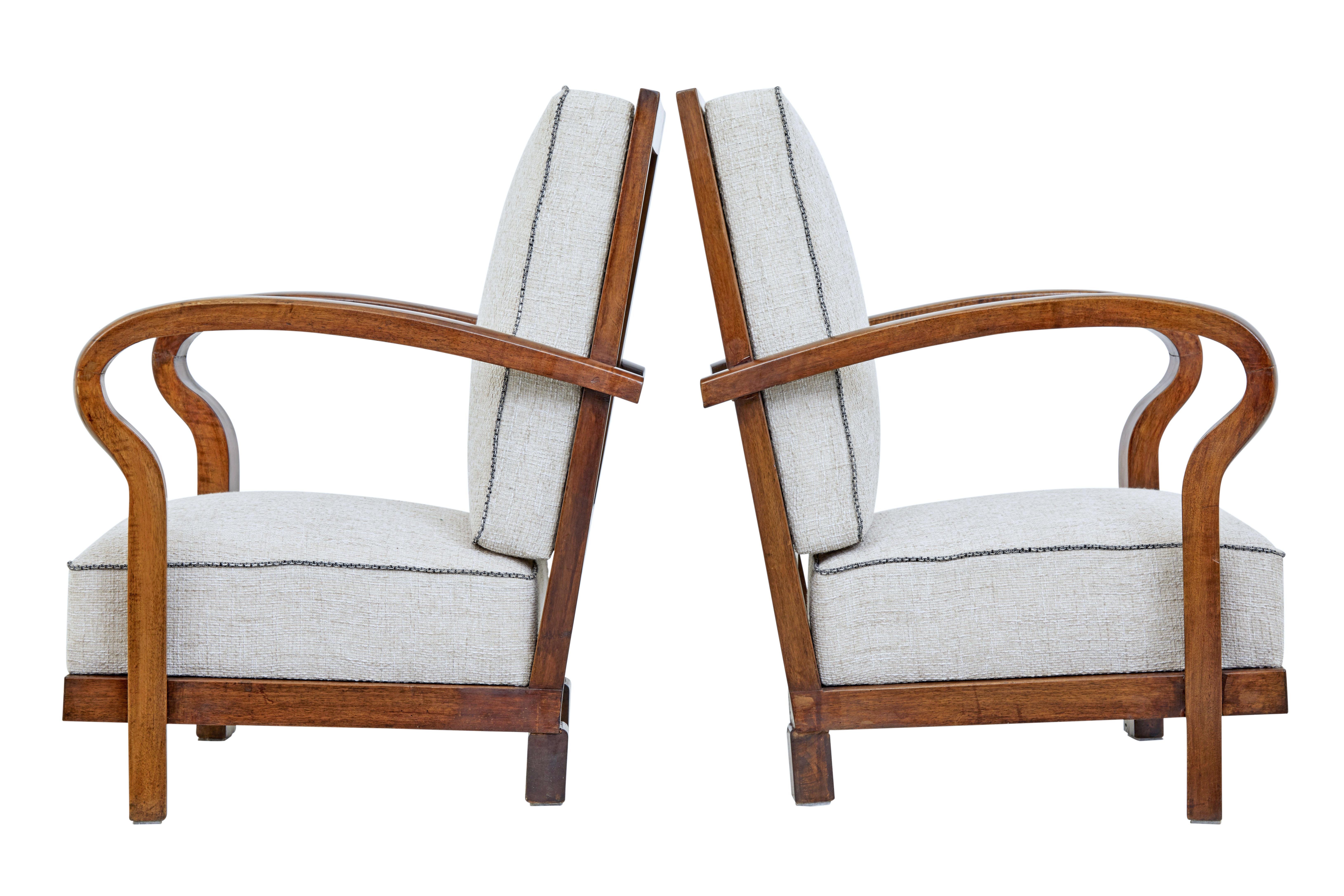 Pair of mid-20th century walnut open frame lounge chairs, circa 1960.

Good quality pair of Scandinavian Art Deco inspired lounge chairs. Beautifully shaped flowing arms that link from the backrest to the base.

Standing on short block