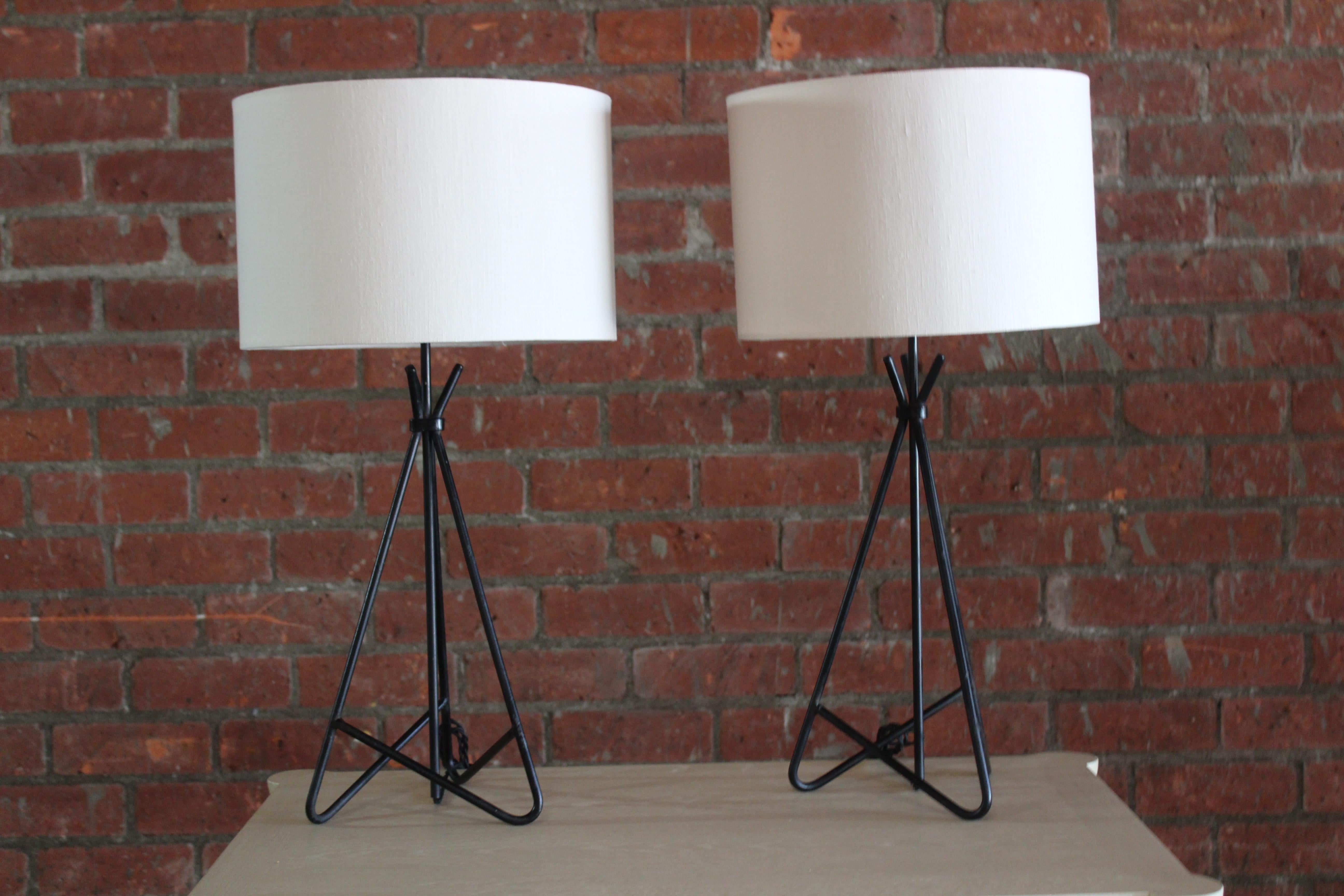 Pair of vintage 1950s iron table lamps in the style of Jean Royere. Each lamp has been rewired in black twisted silk cord and includes a custom shade in Belgian linen. Sold as pair. Each lamp has a base that is 10