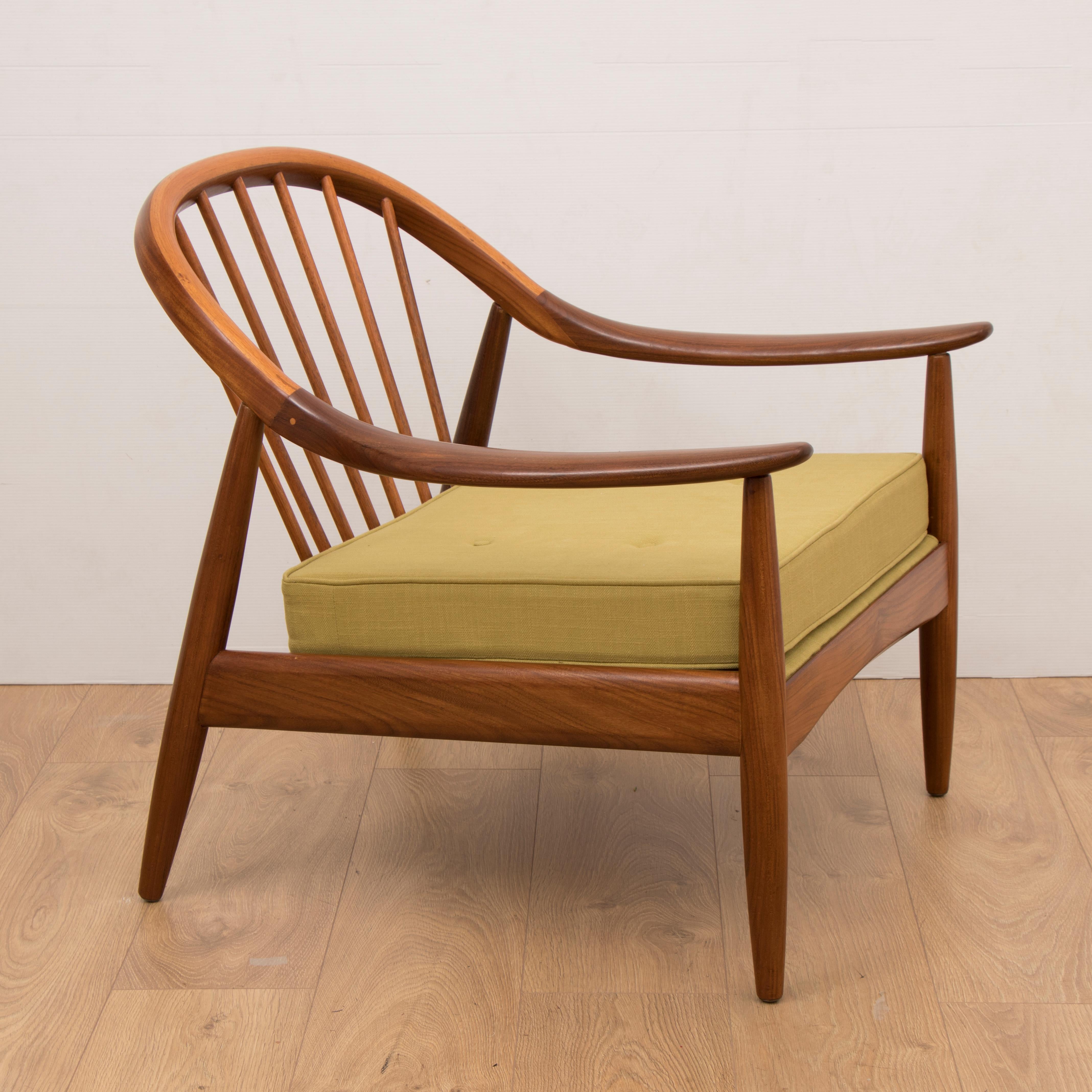 A pair of beautifully made midcentury 1960s Greaves and Thomas teak bentwood armchairs. The chairs are formed from steam bent solid teak with curved sweeping armrests and a flared spindle back. The legs are constructed from turned, tapered, flared