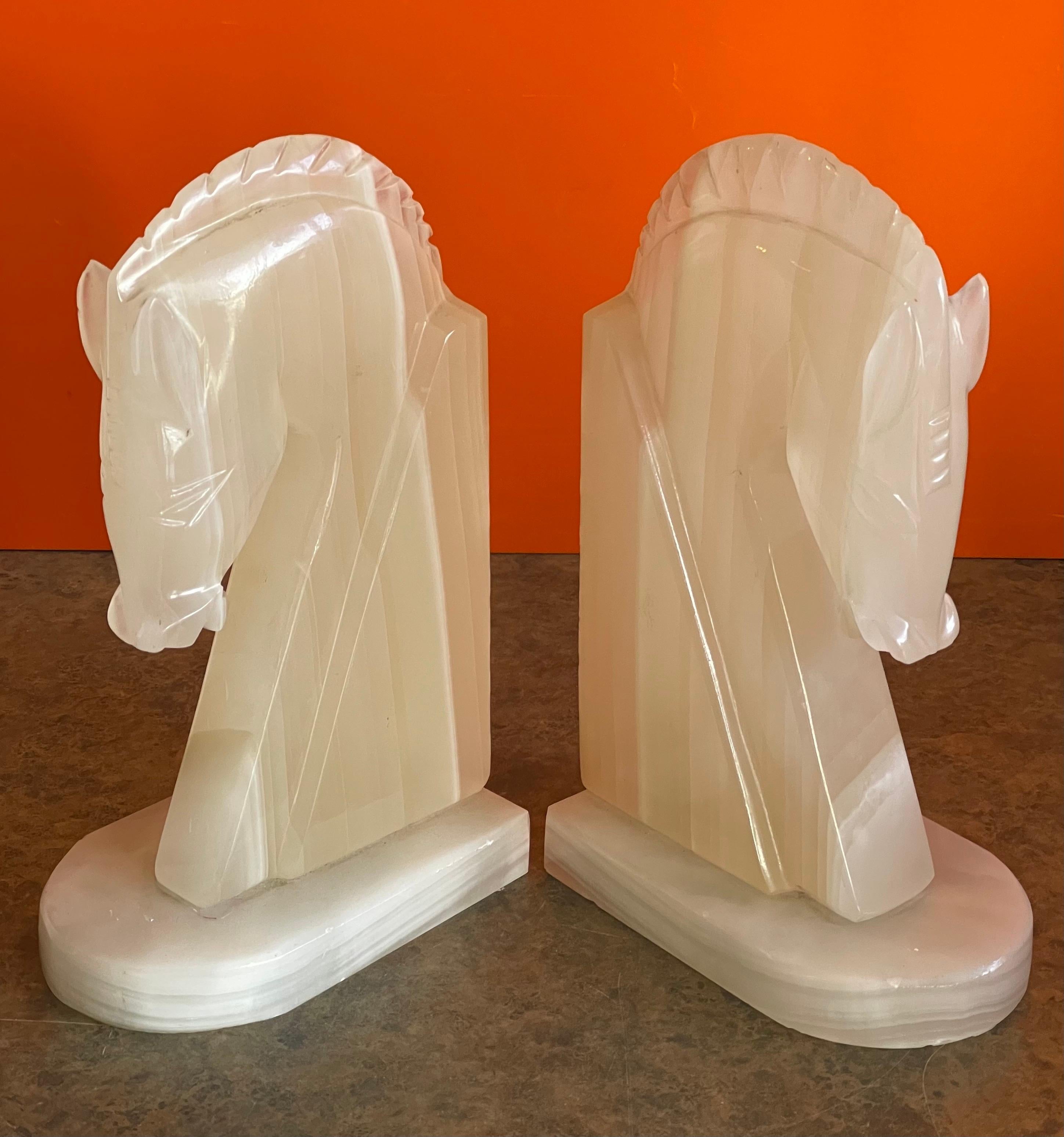 Very stylish pair of mid-century alabaster horse head bookends, circa 1970s. The bookends are heavy and solid and well crafted. They measure 10.5