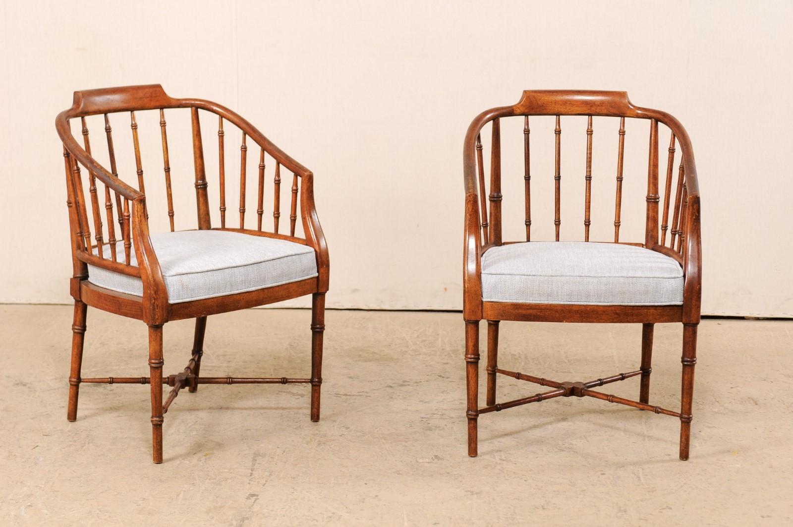 A pair of midcentury American armchairs with upholstered seats and faux-bamboo carved frames. This vintage pair of Hollywood Regency inspired occasional chairs have an ashwood frame, which has been carved to mimic the design of bamboo. The faux