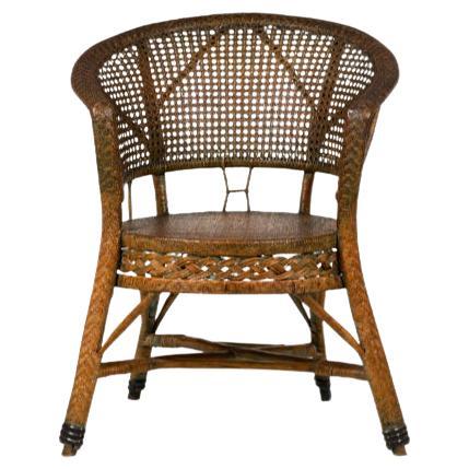 Pair of Mid-Century American wicker and wood pull up chairs with a curved horseshoe-form crest rail supported by two back posts branching out in Y-shaped formation, caned circular seats and backs, and front braided aprons, resting on splayed legs