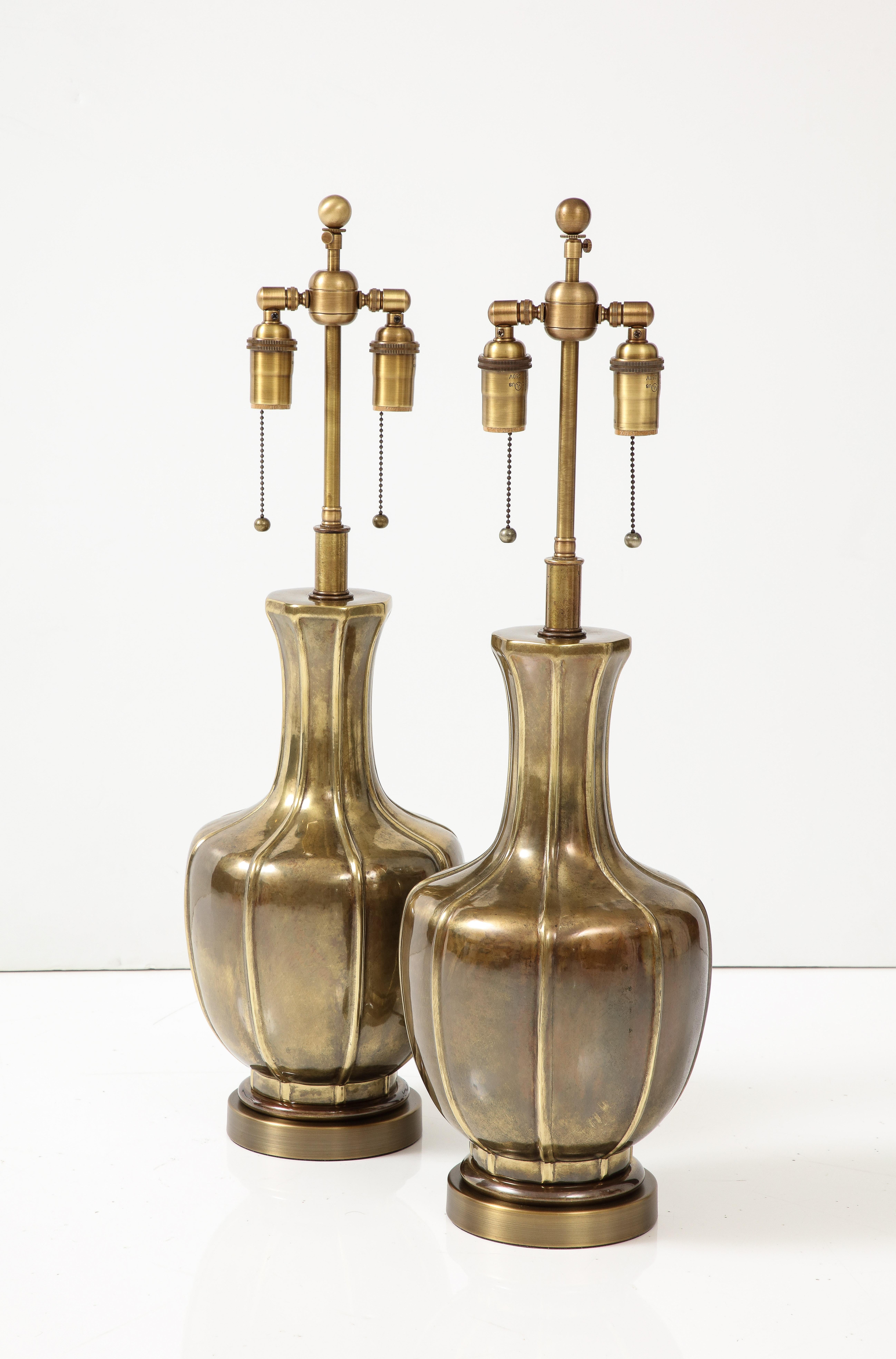 Paire de lampes des années 1960 d'influence Arts and Crafts par Frederick Cooper.
Les lampes ont une magnifique finition en laiton vieilli et ont été recâblées avec des fils de cuivre. 
doubles grappes réglables en laiton antique pouvant accueillir