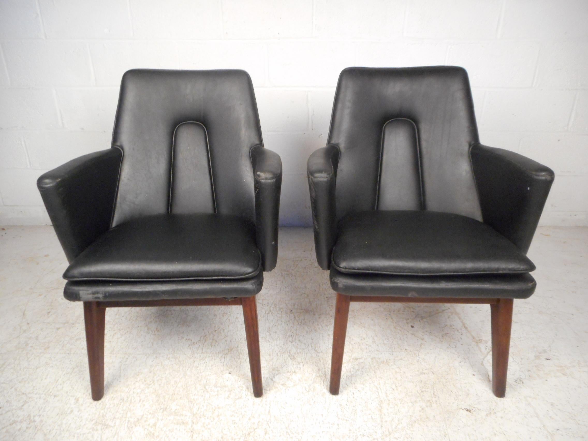Stylish pair of Danish modern armchairs. Sleek angular seats are supported by sculpted wooden legs, giving these chairs an interesting visual profile. Please confirm item location with dealer (NJ or NY).