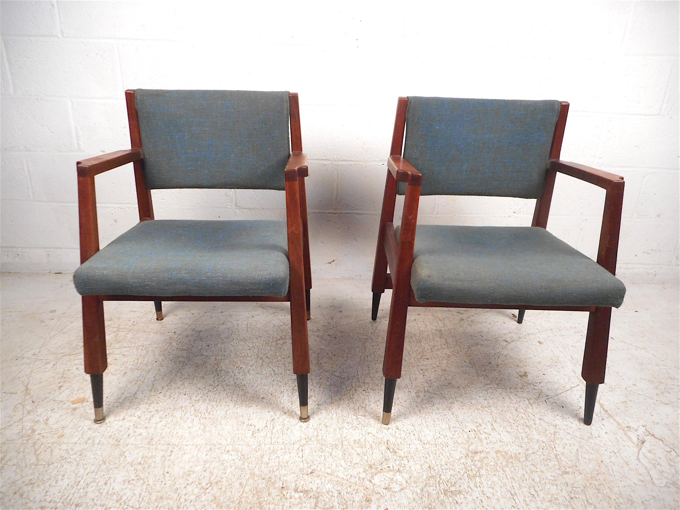 Stylish pair of midcentury armchairs. Sturdy walnut construction with a sleek angular frame, sculpted armrests, and covered in a vintage blue upholstery. This pair is sure to make an impressive addition to any modern interior's seating arrangement.
