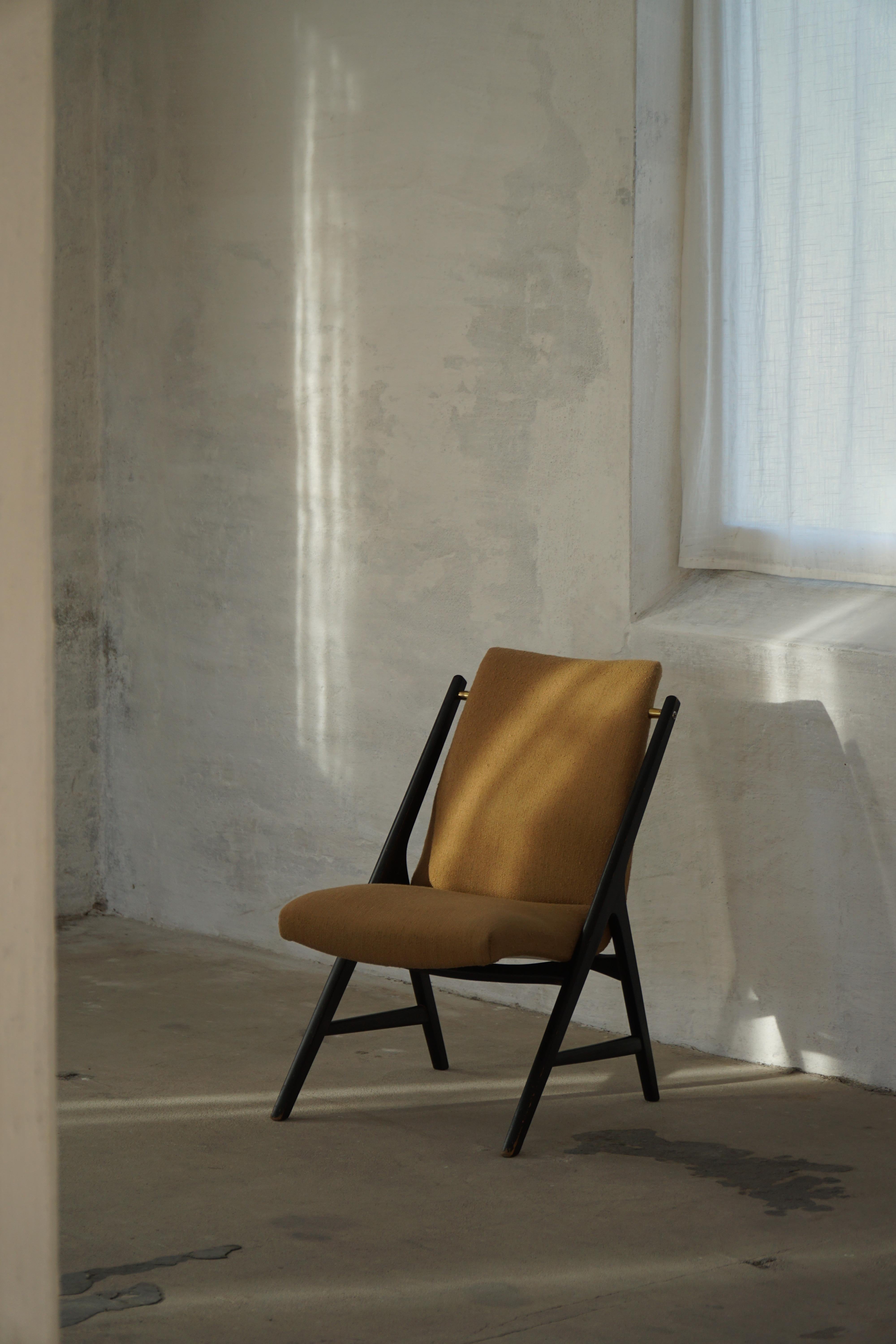 Paire de fauteuils élégants du milieu du siècle dernier, datant des années 1950-1960, avec un cadre en bois peint foncé accentué par des vis en laiton, magnifiquement contrasté par une tapisserie rustique en bouclette de couleur beige. Le tissu