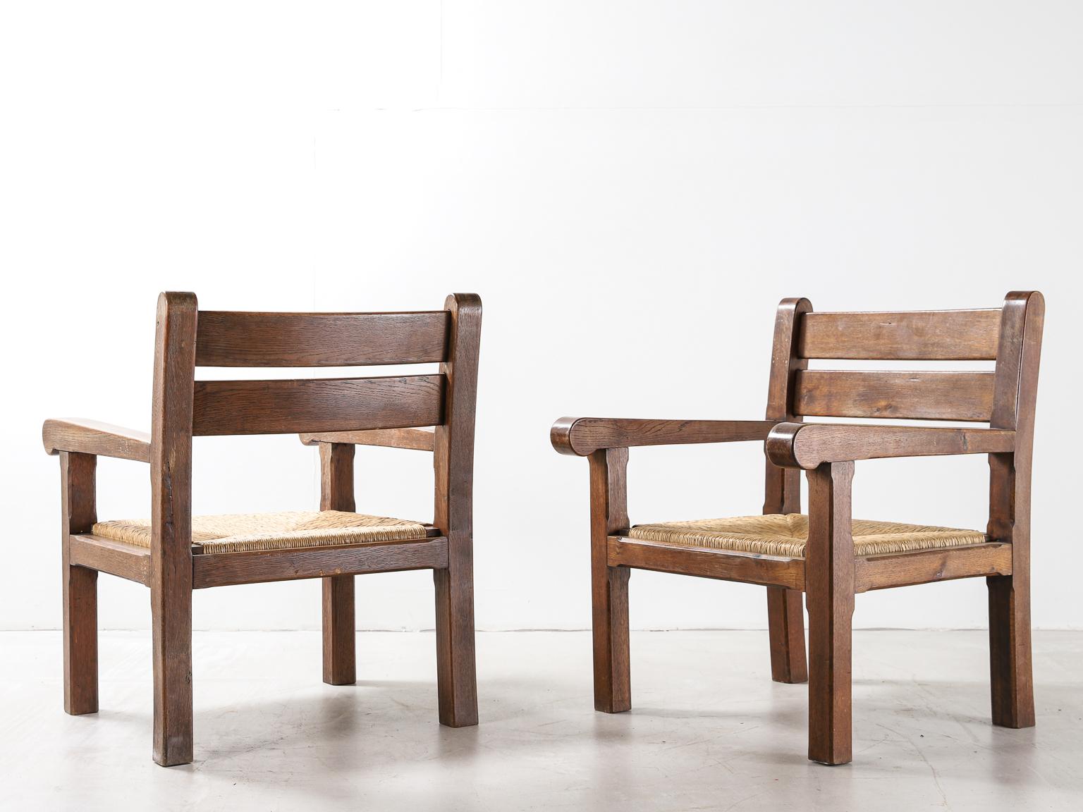 A beautifully simple pair of armchairs made by a French Breton cabinetmaker in the 1950s. The elegant mid to dark oak frames are complimented by the natural, original braided straw seats.