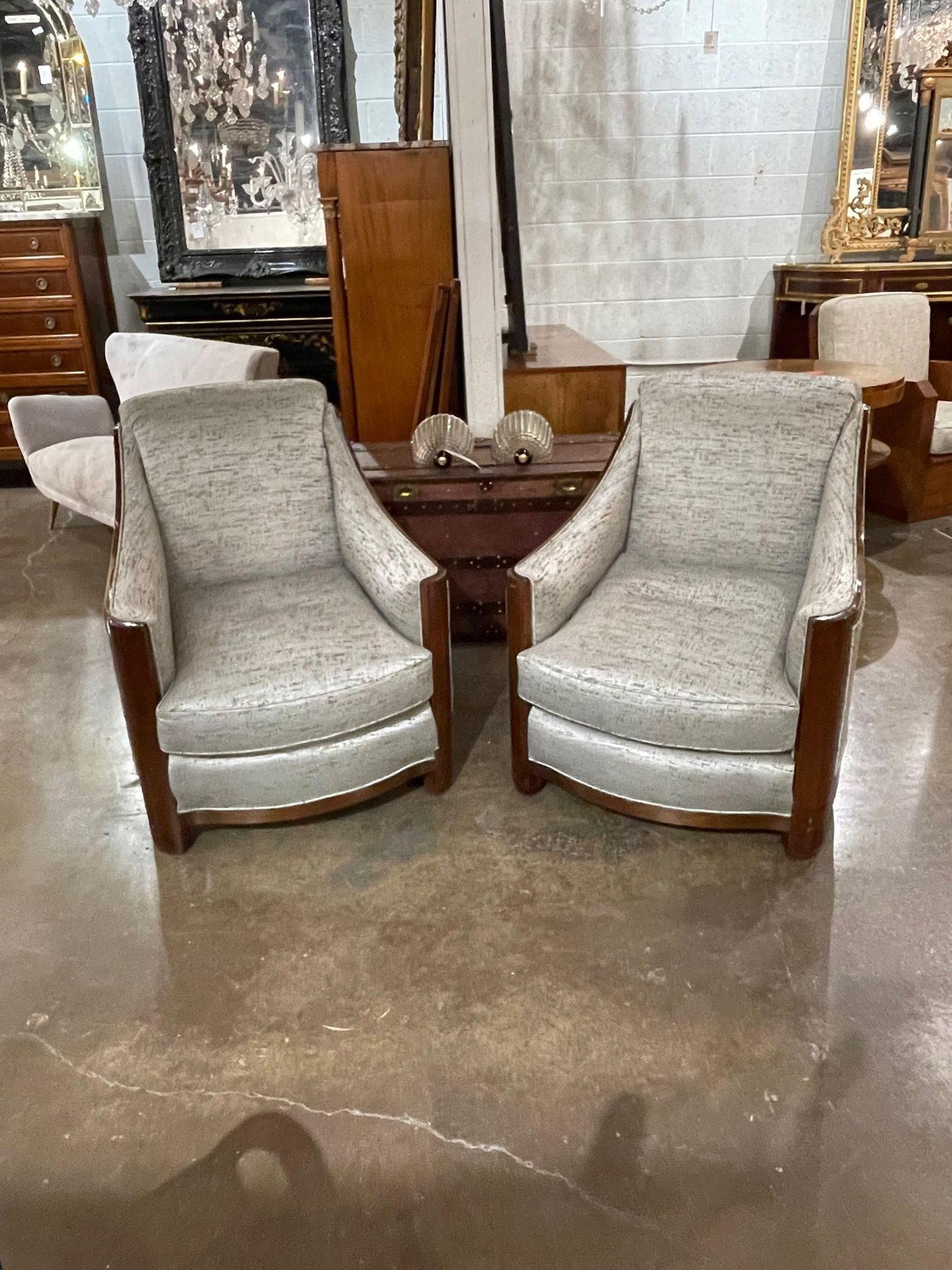 Handsome pair of mid-century Art Deco style club chairs upholstered in a beautiful neutral fabric. This pair would work well in a variety of settings. Exceptional quality. Stunning!!.