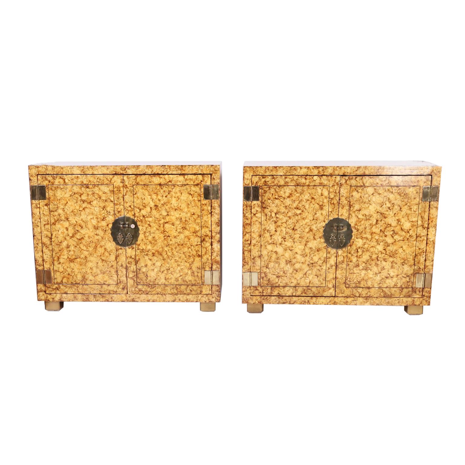 Striking pair of vintage cabinets crafted with hardwoods in a sleek asian style with brass hardware and featuring a chic stylized faux tortoise finish. Signed Henredon in a drawer.