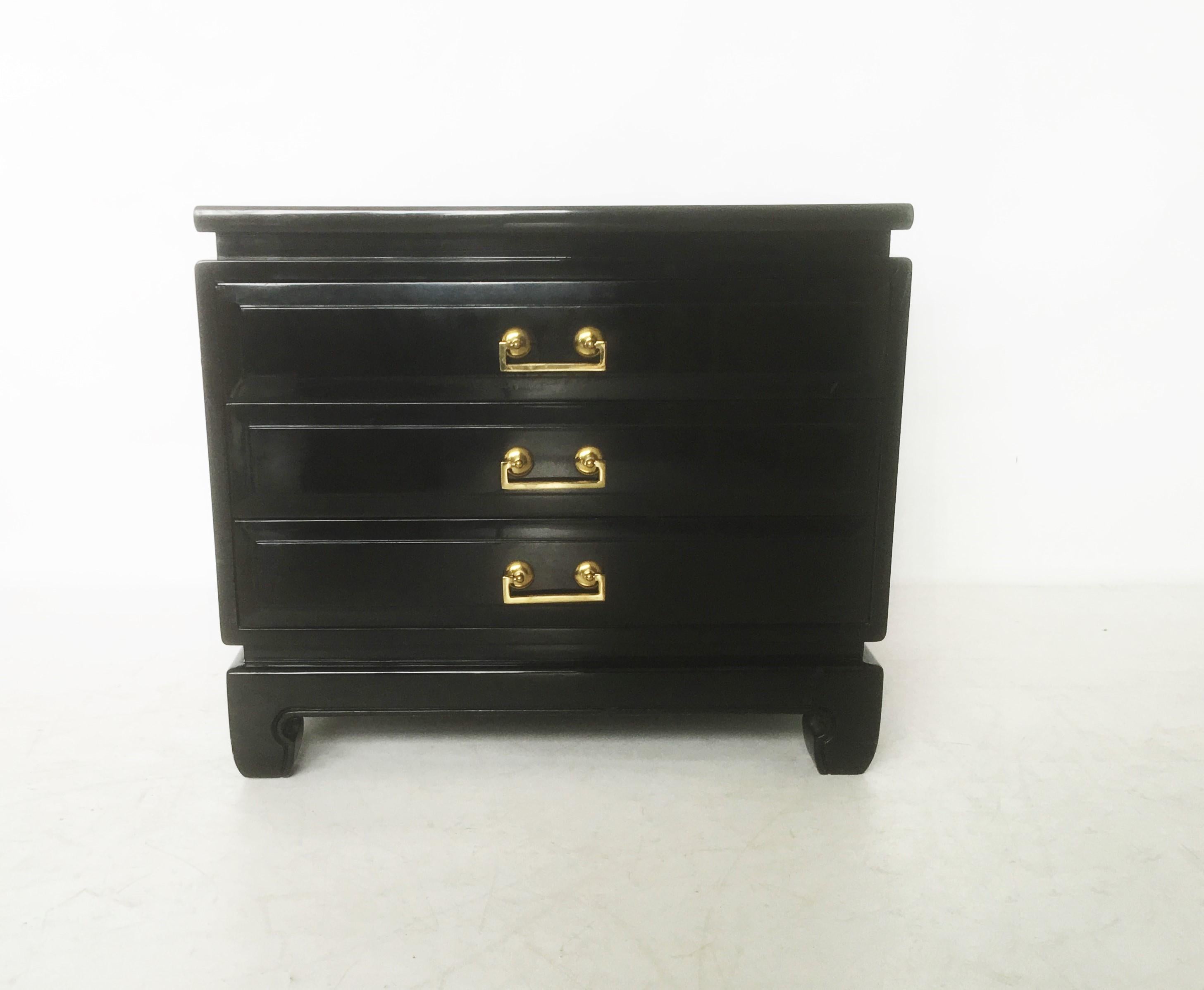 Freshly lacquered pair of vintage Hollywood Regency midcentury nightstands, circa 1950s-1960s. Superior craftsmanship tables made of solid wood. The tables feature three drawers, original brass hardware handles and beautiful Ming style legs. The