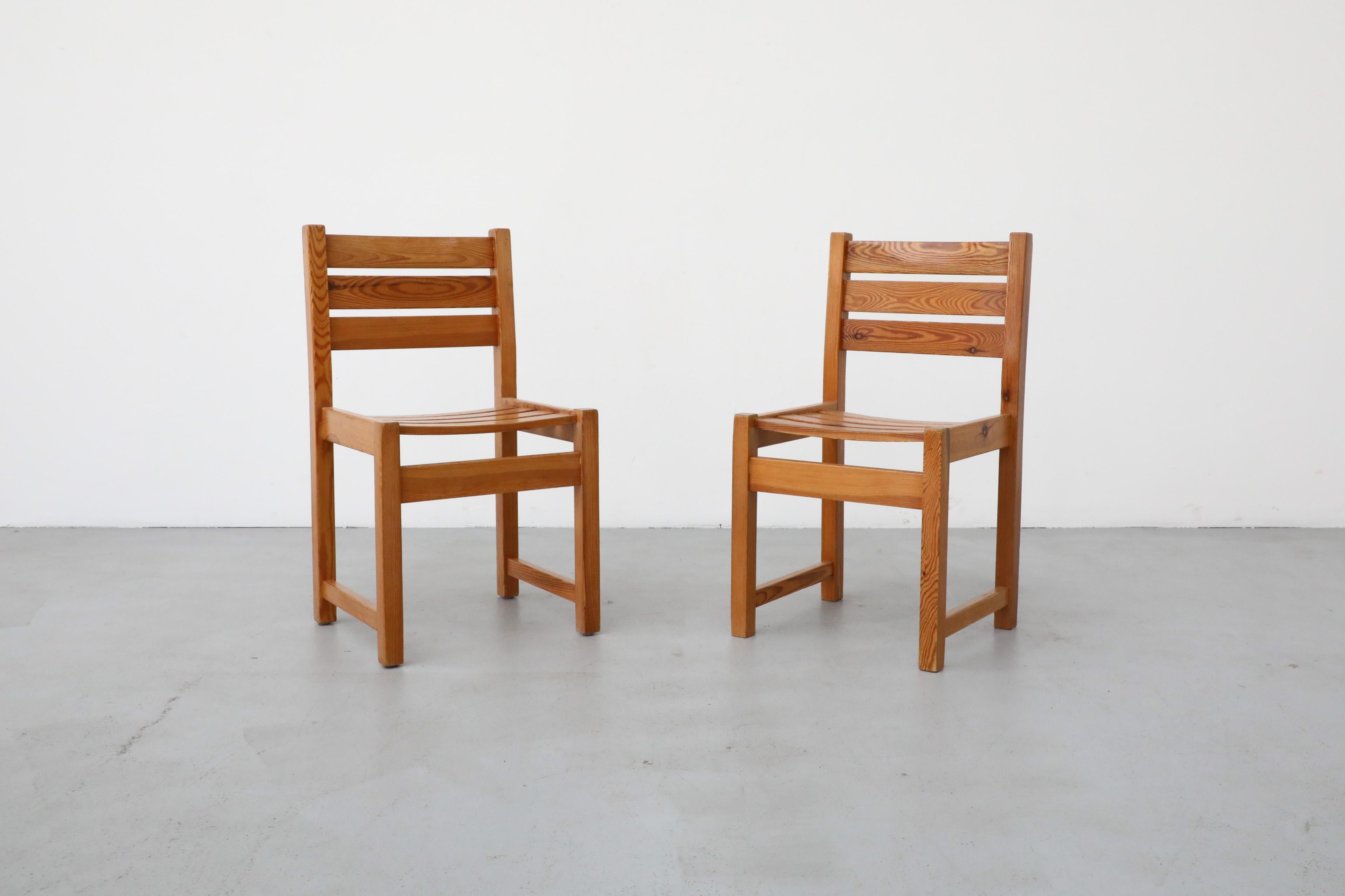 These Ate van Apeldoorn style pine dining chairs have handsome grain patterns, ladder backs and slatted seats. The chairs are in original condition with some visible wear, including some light scratches and normal wear consistent with their age and