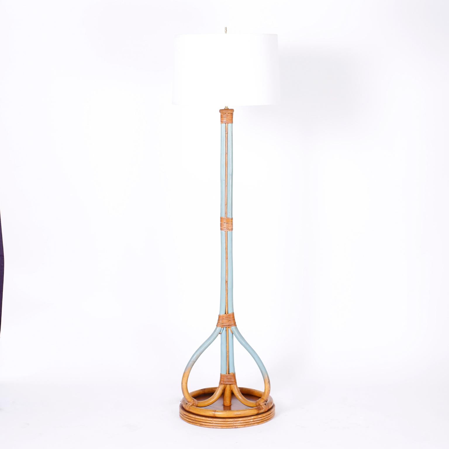 Stand out pair of midcentury floor lamps with surprising yet welcome blue paint, crafted in bamboo and bent bamboo with wrapped rattan over a base with bamboo rings around a mahogany disk.