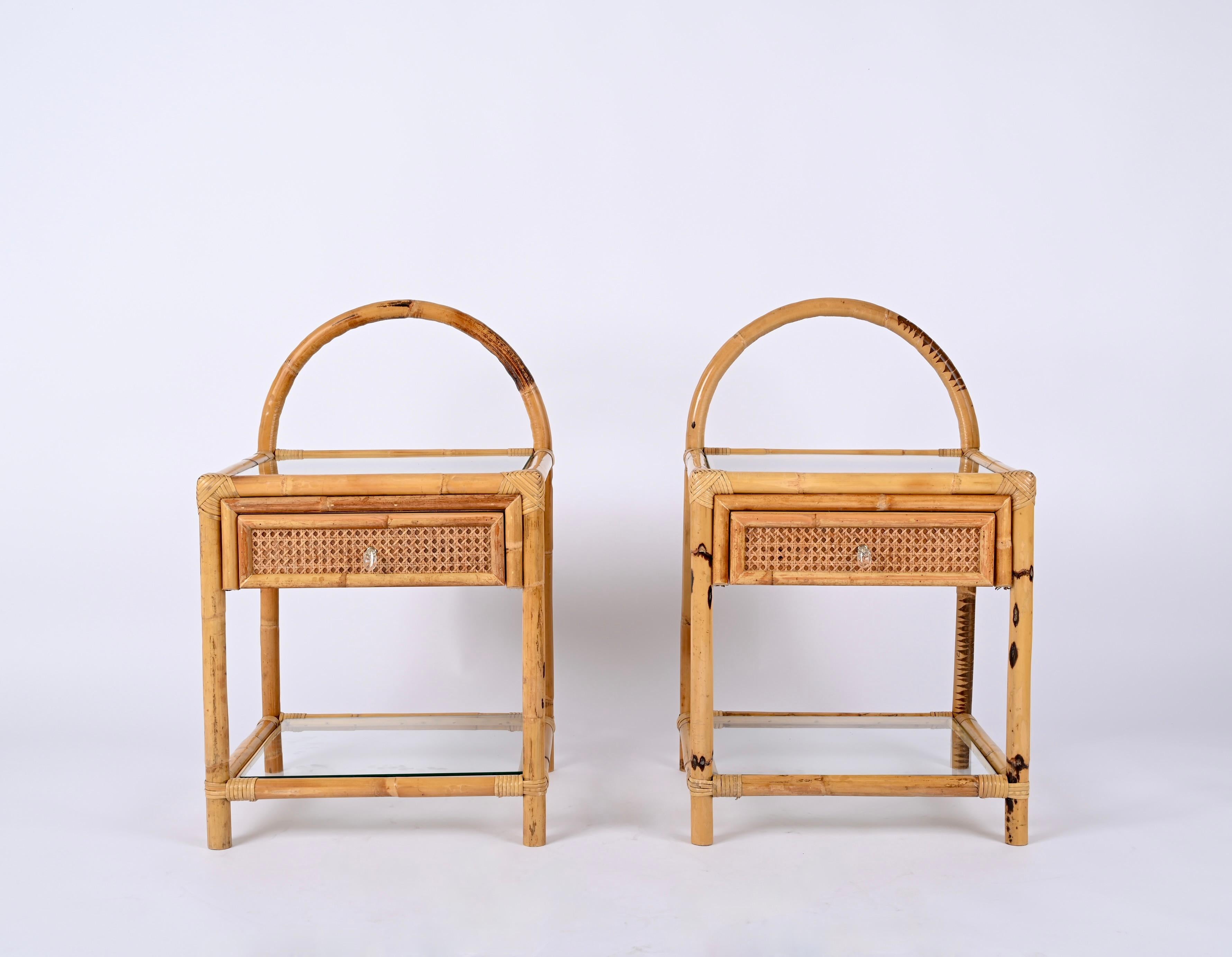 Astonishing pair of Mid-Century Bamboo and Rattan Nightstands, designed in Italy in the 70's.

These unique bedside tables feature a structure made in curved bamboo decorated all around by a lovely hand-woven Vienna straw wicker, the whole is