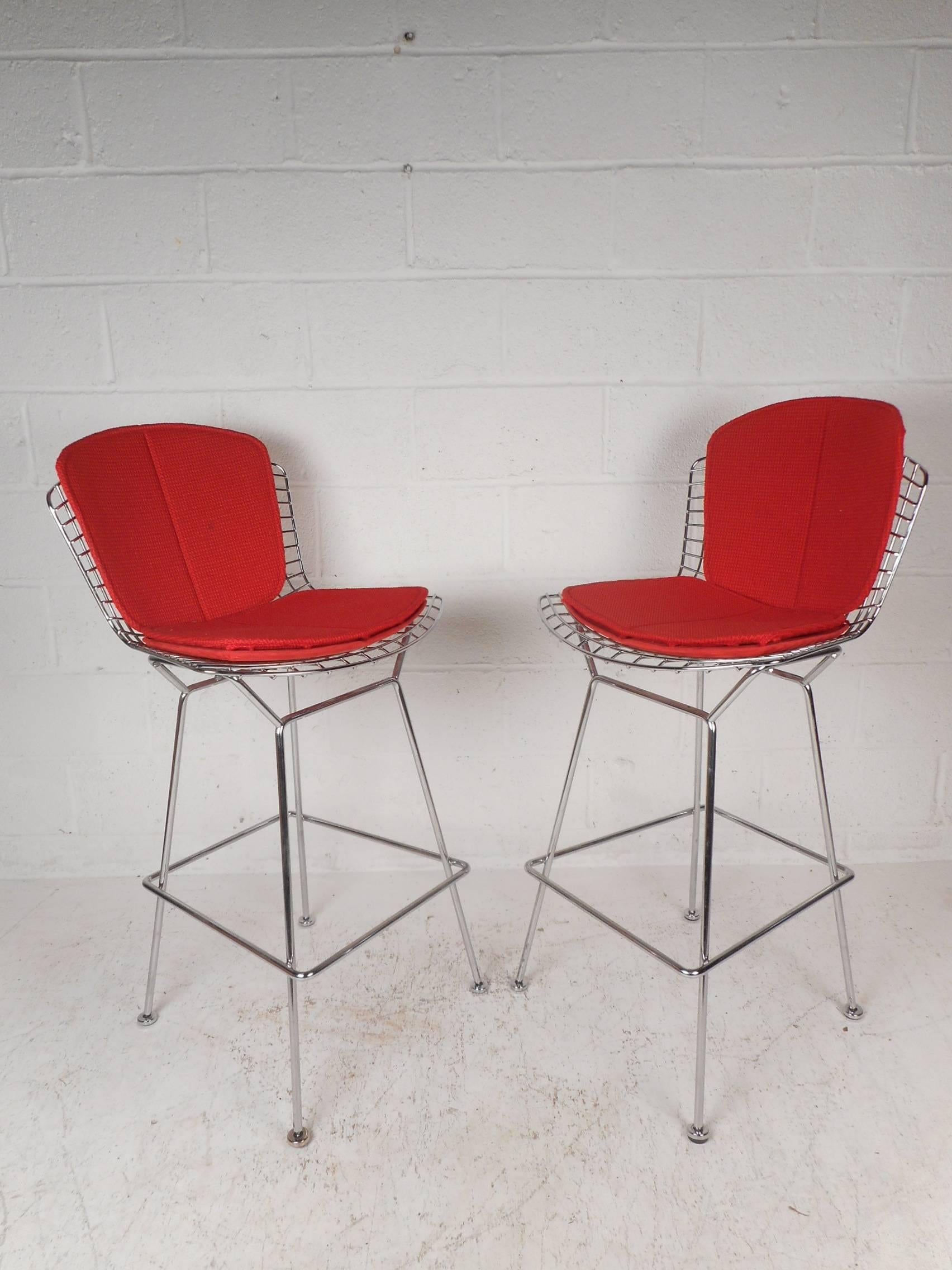Stunning vintage modern bar stools with a metal wire frame and four splayed legs. These stylish chairs have two cushions on the seat covered in a plush elaborate red fabric. This extremely comfortable and sturdy pair of bar stools make the perfect